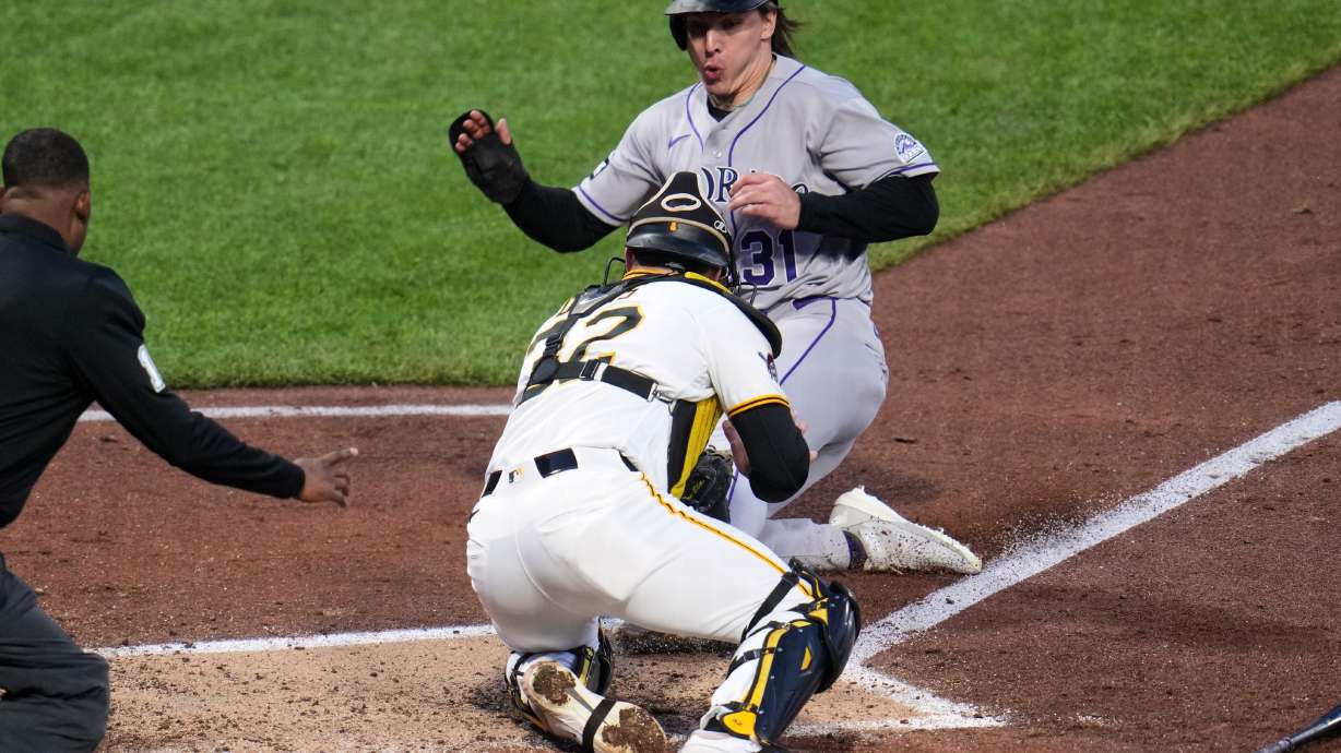 Colorado Rockies' Jake McCarthy, rear, is tagged out by Pittsburgh Pirates catcher Henry Davis attempting to score on a fielder's choice by Brett Sullivan during the fifth inning of a baseball game in Pittsburgh, Wednesday, May 13, 2026.