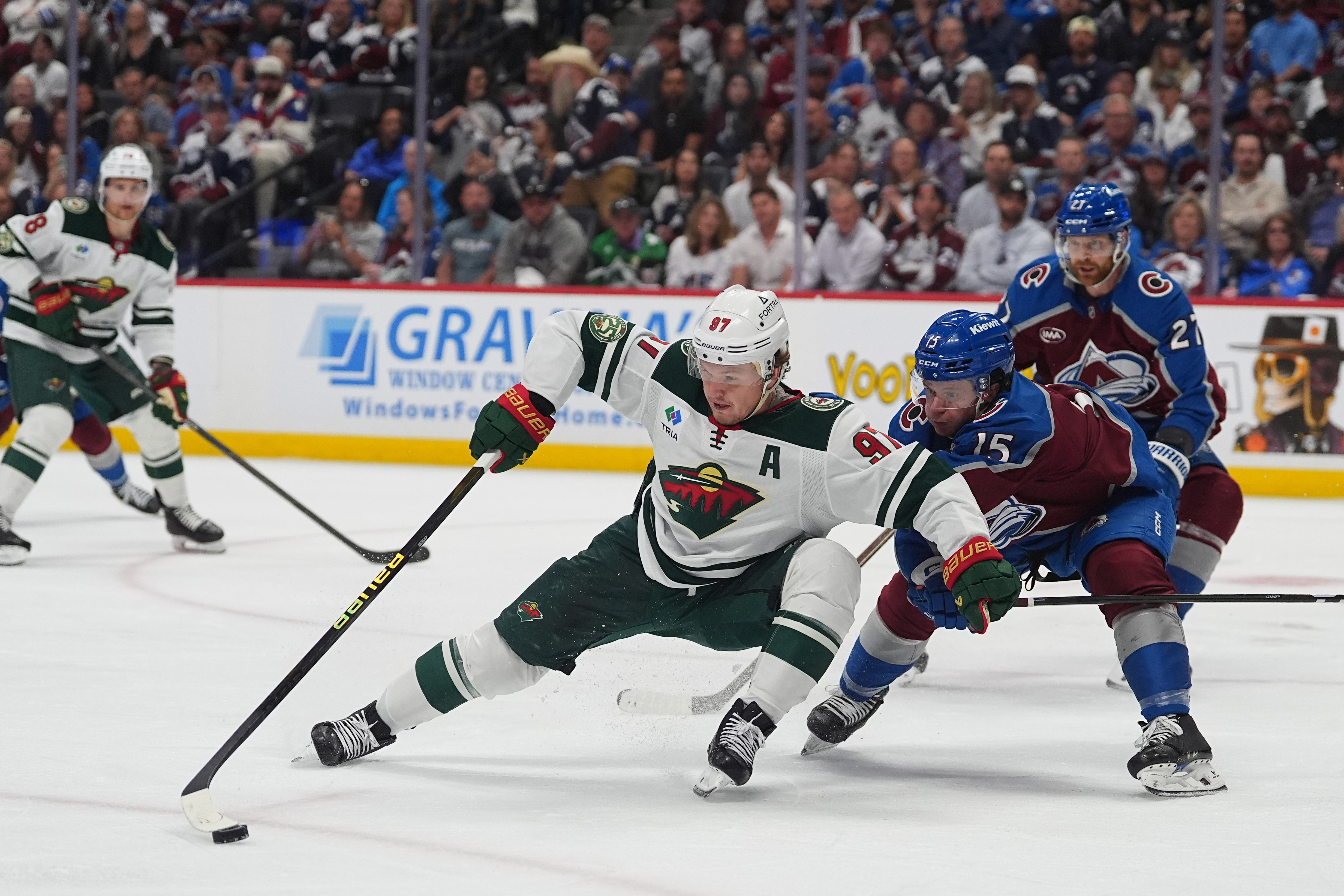 Minnesota Wild left wing Kirill Kaprizov, center, collects the puck as Colorado Avalanche defenseman Jack Ahcan covers in the second period of Game 5 of an NHL Stanley Cup hockey second-round playoff series, Wednesday, May 13, 2026, in Denver. 
