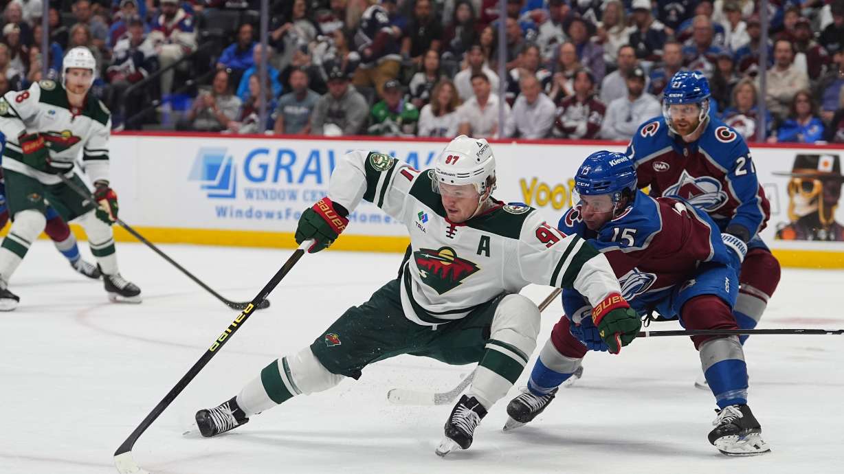 Minnesota Wild left wing Kirill Kaprizov, center, collects the puck as Colorado Avalanche defenseman Jack Ahcan covers in the second period of Game 5 of an NHL Stanley Cup hockey second-round playoff series, Wednesday, May 13, 2026, in Denver.