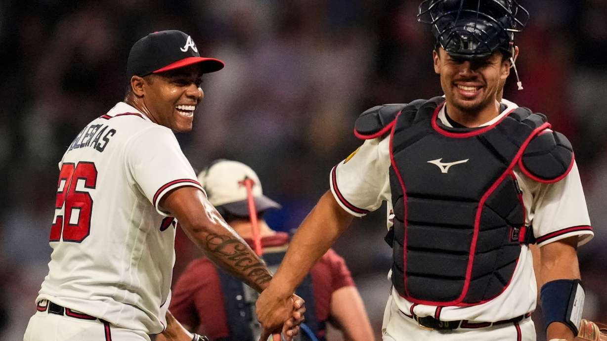 Atlanta Braves pitcher Raisel Iglesias celebrates a win over the Chicago Cubs with Drake Baldwin after a baseball game, Wednesday, May 13, 2026, in Atlanta.