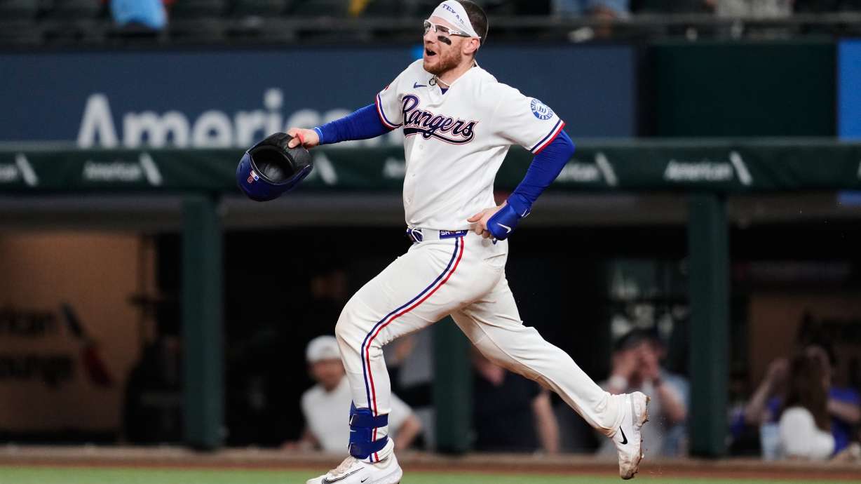 Texas Rangers' Danny Jansen celebrates his run-scoring single as he rounds first in the ninth inning of a baseball game against the Arizona Diamondbacks Wednesday, May 13, 2026, in Arlington, Texas.