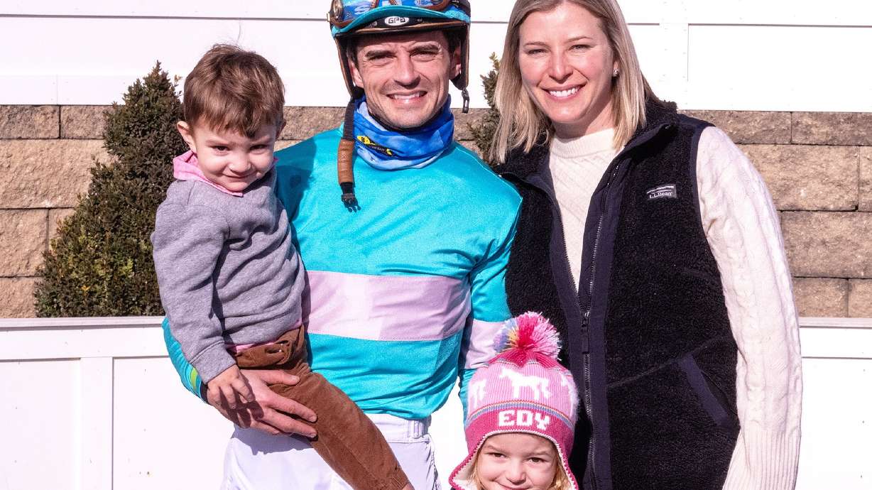 In this image provided by the The Maryland Jockey Club, husband and wife, jockey Sheldon Russell and trainer Brittany Russell, pose for a photo in the winner's circle with son Rye and daughter Edy, after Point Dume won the third race, Dec. 31, 2023, at Laurel Park in Laurel, Md.