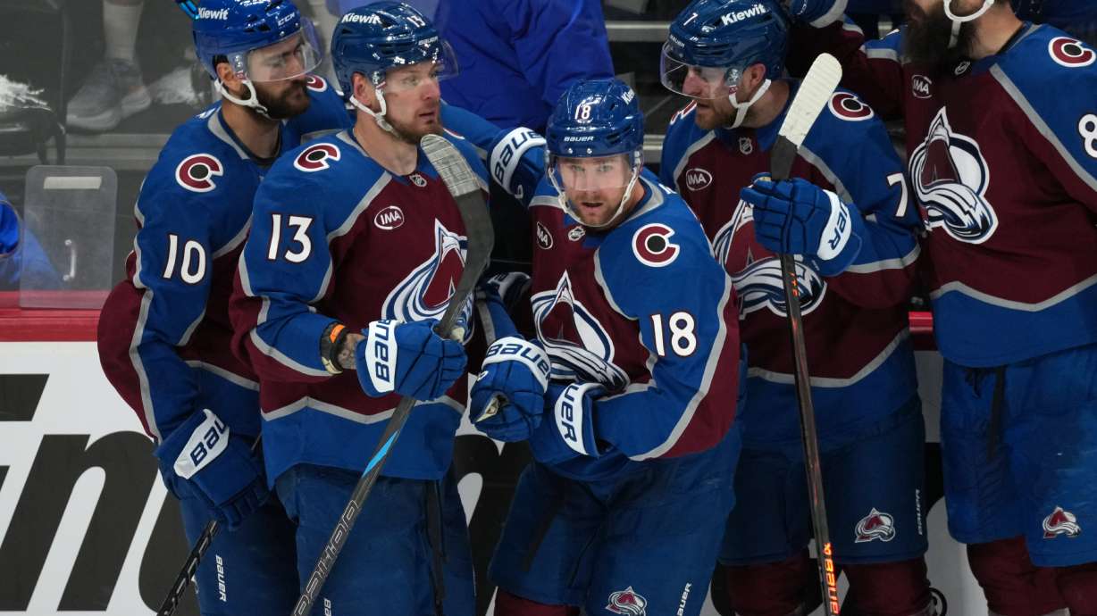 Colorado Avalanche center Jack Drury, center, is congratulated by, from left, center Nicolas Roy, right wing Valeri Nichushkin, and defensemen Devon Toews and Brent Burns in the third period of Game 5 of an NHL Stanley Cup hockey second-round playoff series against the Minnesota Wild Wednesday, May 13, 2026, in Denver.