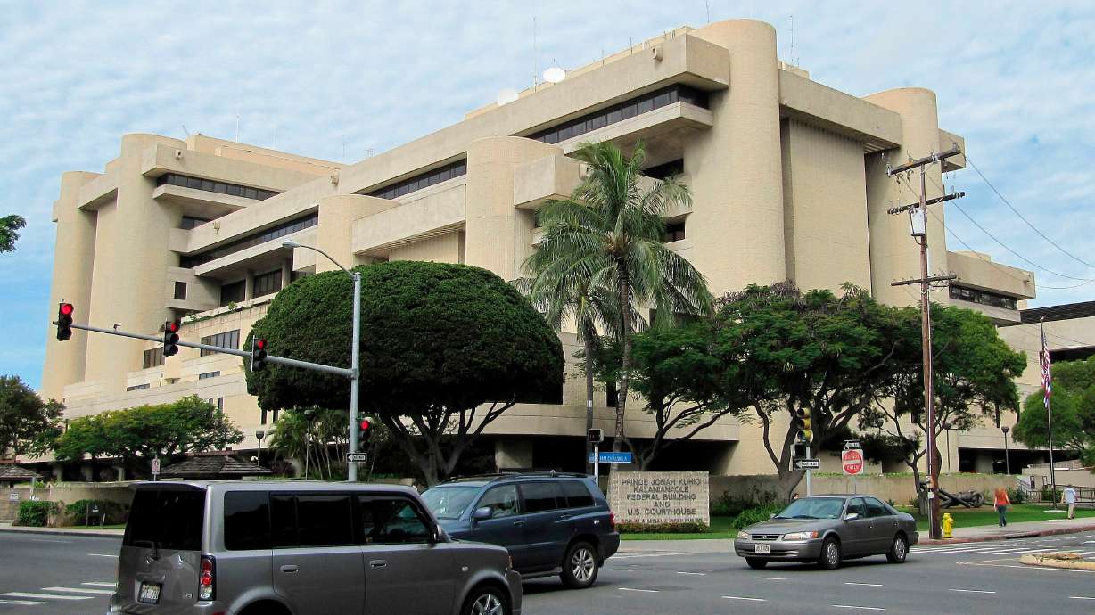 Cars pass in front of the federal building housing the U.S. District Court in Honolulu on March 7, 2014.