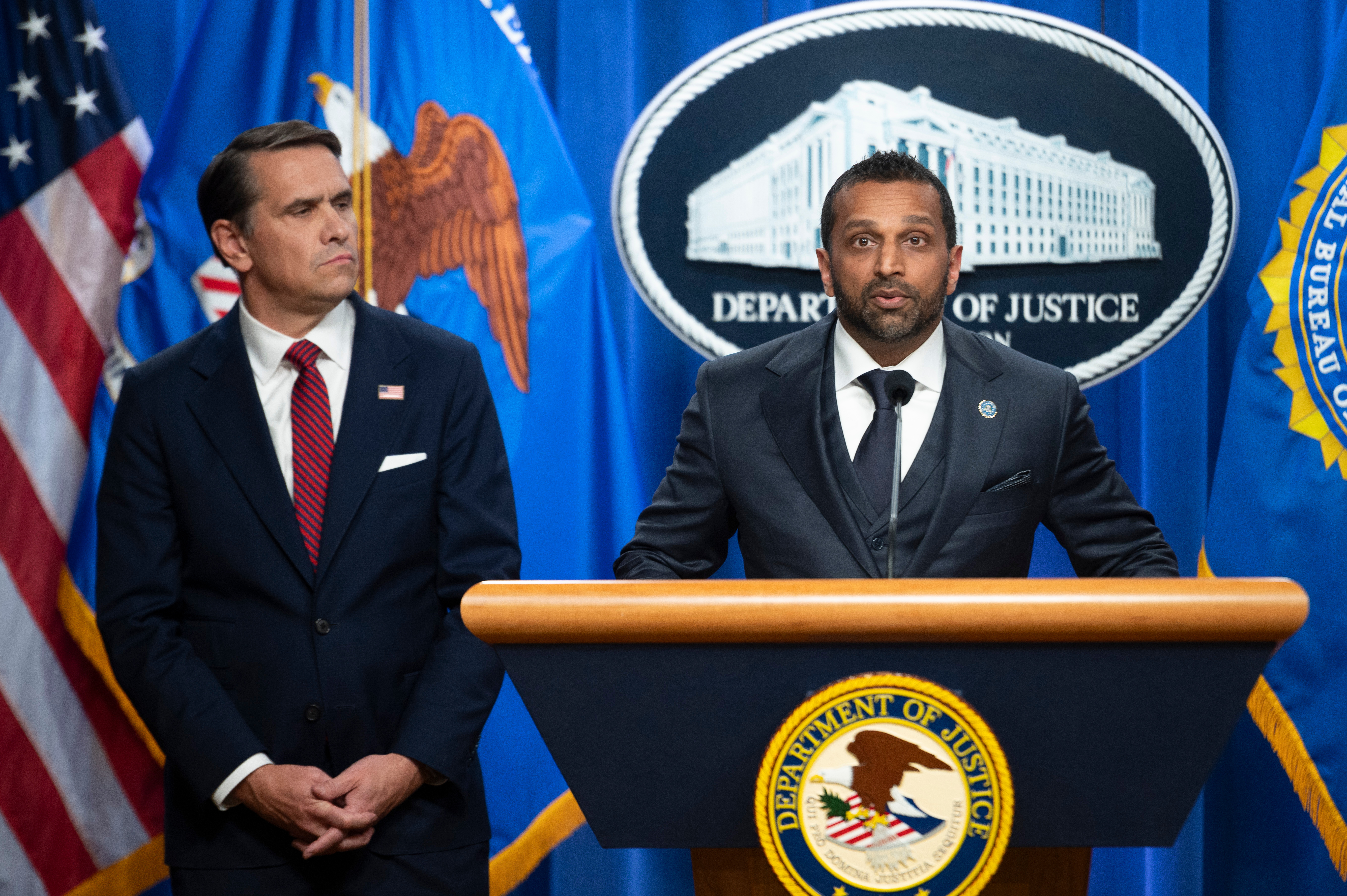 Acting Attorney General Todd Blanche looks on as FBI Director Kash Patel speaks about former FBI Director James Comey's indictment, at the Justice Department in Washington, April 28. A judge put off a decision in Comey's third criminal indictment on Friday.