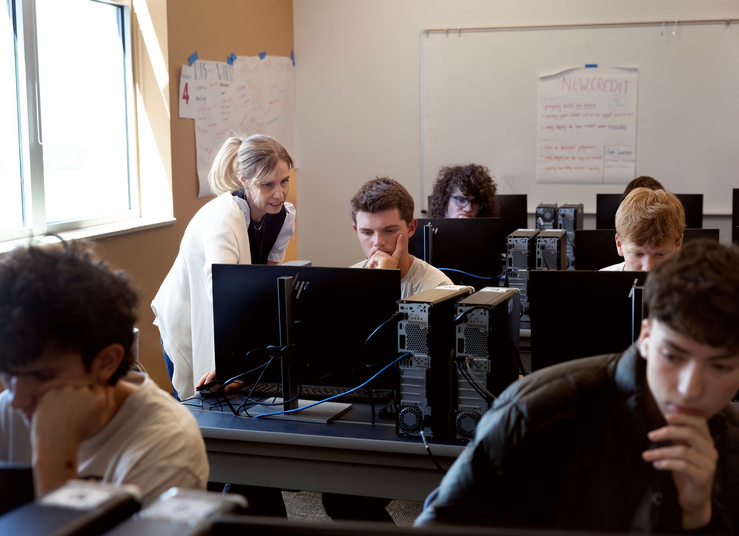 Michelle Butler works with Oliver Pohlman during her financial literacy class at Brighton High School in Cottonwood Heights on Thursday.