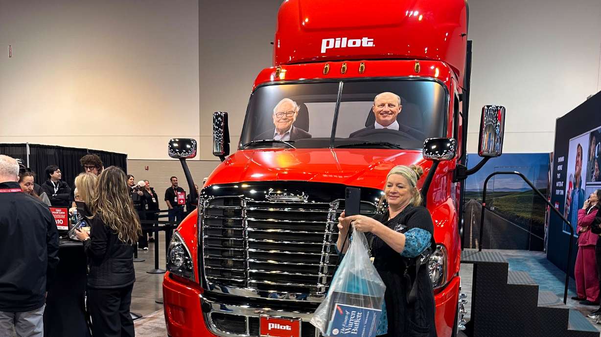 A Berkshire Hathaway shareholder takes a selfie in front of a Pilot truck stops semi truck with pictures of Berkshire's top two executives behind the wheel: new CEO Greg Abel and Chairman Warren Buffett on Friday, May 1, 2026 in Omaha, Neb.