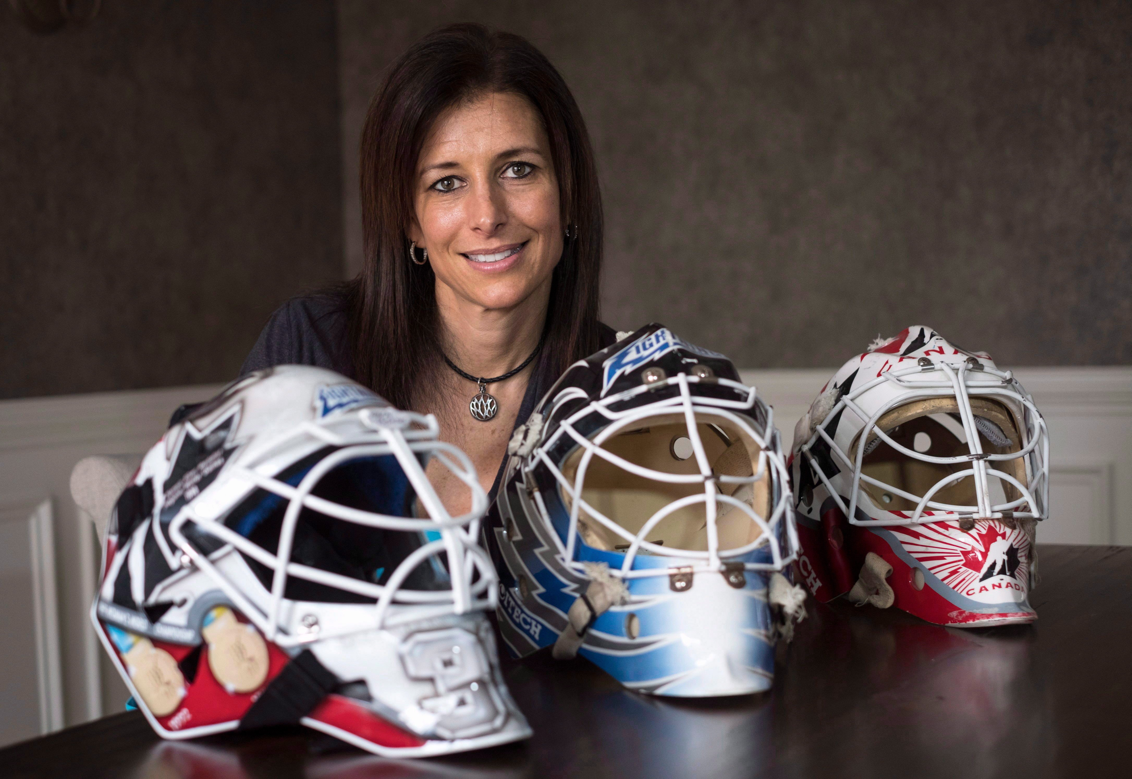 FILE - Former professional goaltender Manon Rheaume poses for a photograph with three of her masks Wednesday, Nov. 2, 2016 in Detroit. 