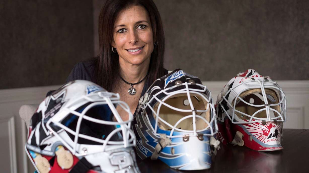 FILE - Former professional goaltender Manon Rheaume poses for a photograph with three of her masks Wednesday, Nov. 2, 2016 in Detroit.