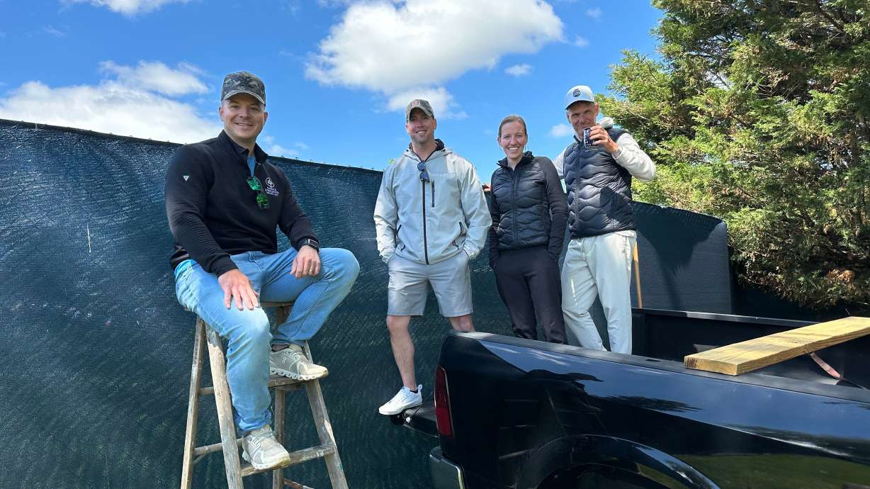 Golf fans pose for a photo while watching the PGA Championship golf tournament from pickup trucks and ladders from neighborhood homes outside Aronimink Golf Club, Friday, May 15, 2026 in Newtown Square, Pa.