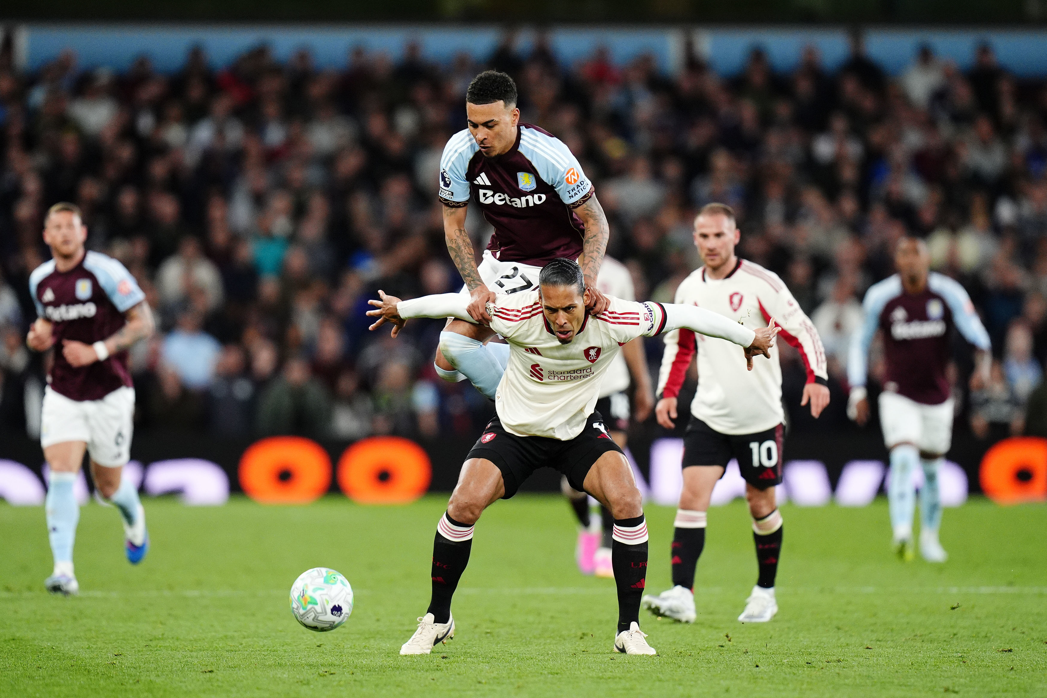 Liverpool's Virgil van Dijk, front, tries to block Aston Villa's Morgan Rogers from the ball during the English Premier League soccer match between Aston Villa and Liverpool in Birmingham, England, Friday, May 15, 2026. 
