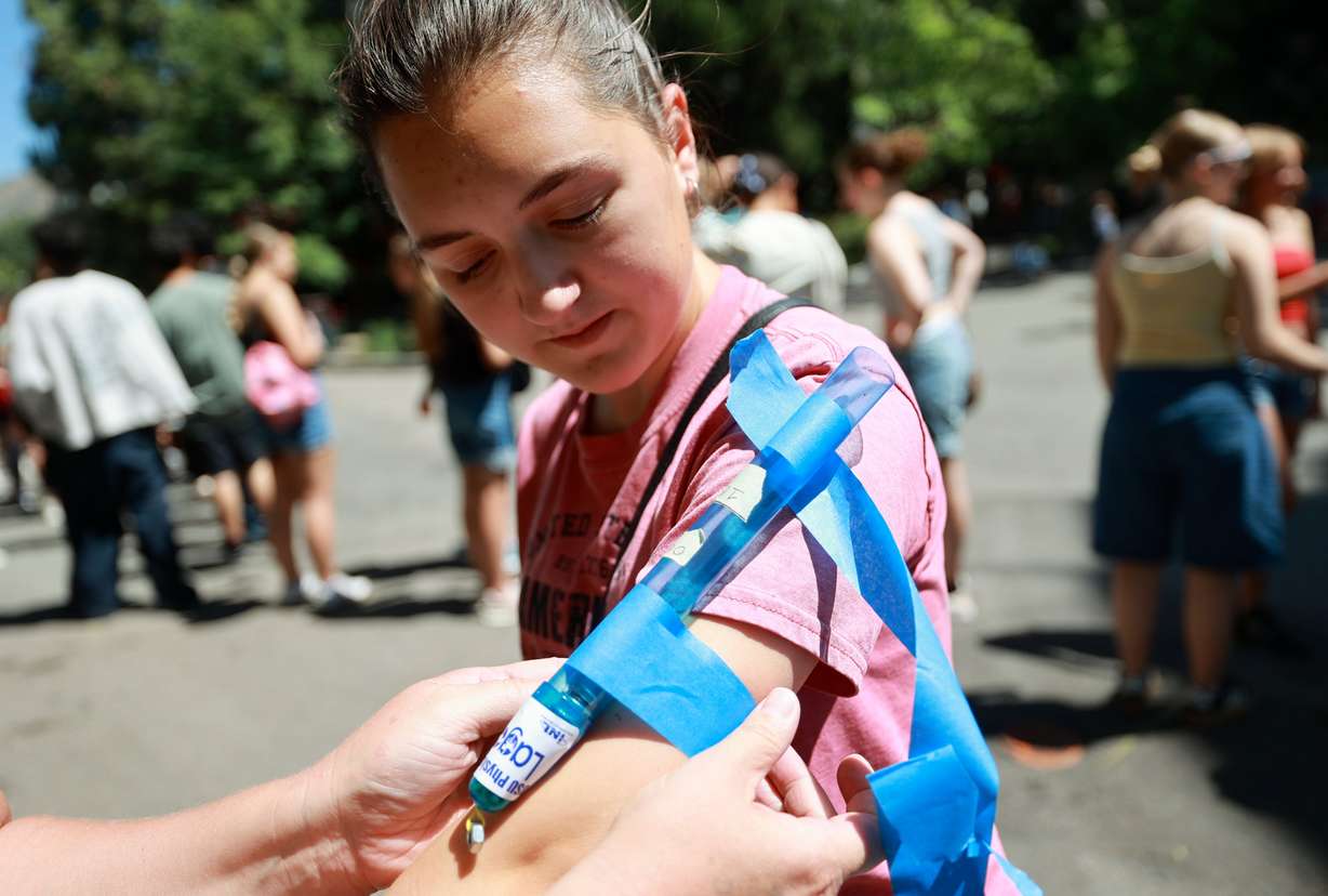 Ninth grader Noelle Brownson, who is home schooled, gets an accelerometer taped to her arm to measure the G-force of the ride Wicked during Utah State University Physics Day at Lagoon Amusement Park in Farmington on Friday.Thousands of teens from Utah, Idaho, Wyoming and Nevada participate in the STEM learning event.