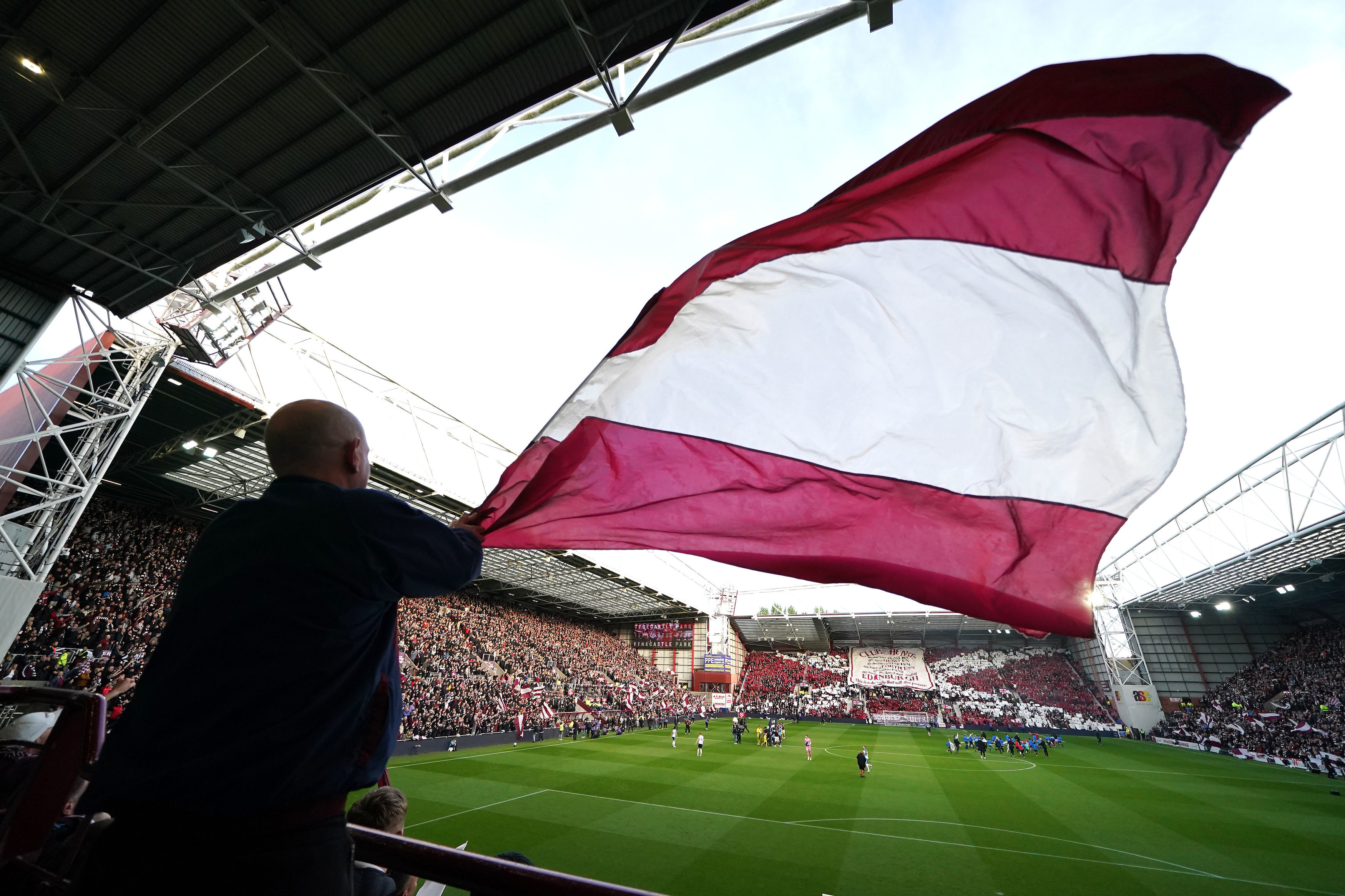 A Heart of Midlothian fan waves a large flag ahead the Scottish Premiership soccer match between Heart of Midlothian and Falkirk, Wednesday, May 13, 2026, in Edinburgh, Scotland. 