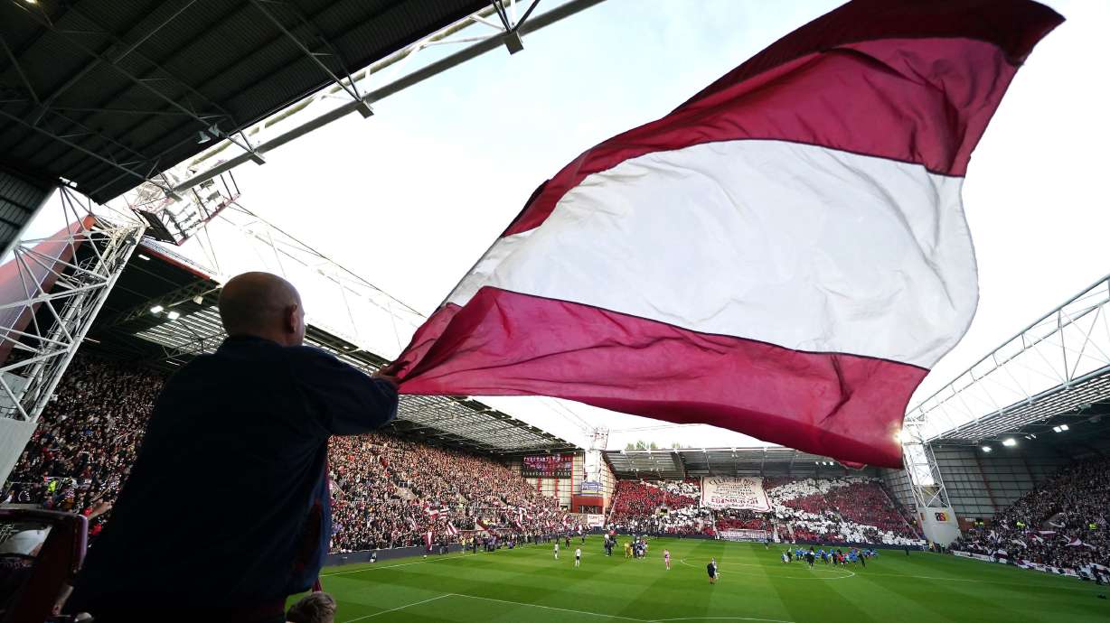A Heart of Midlothian fan waves a large flag ahead the Scottish Premiership soccer match between Heart of Midlothian and Falkirk, Wednesday, May 13, 2026, in Edinburgh, Scotland.
