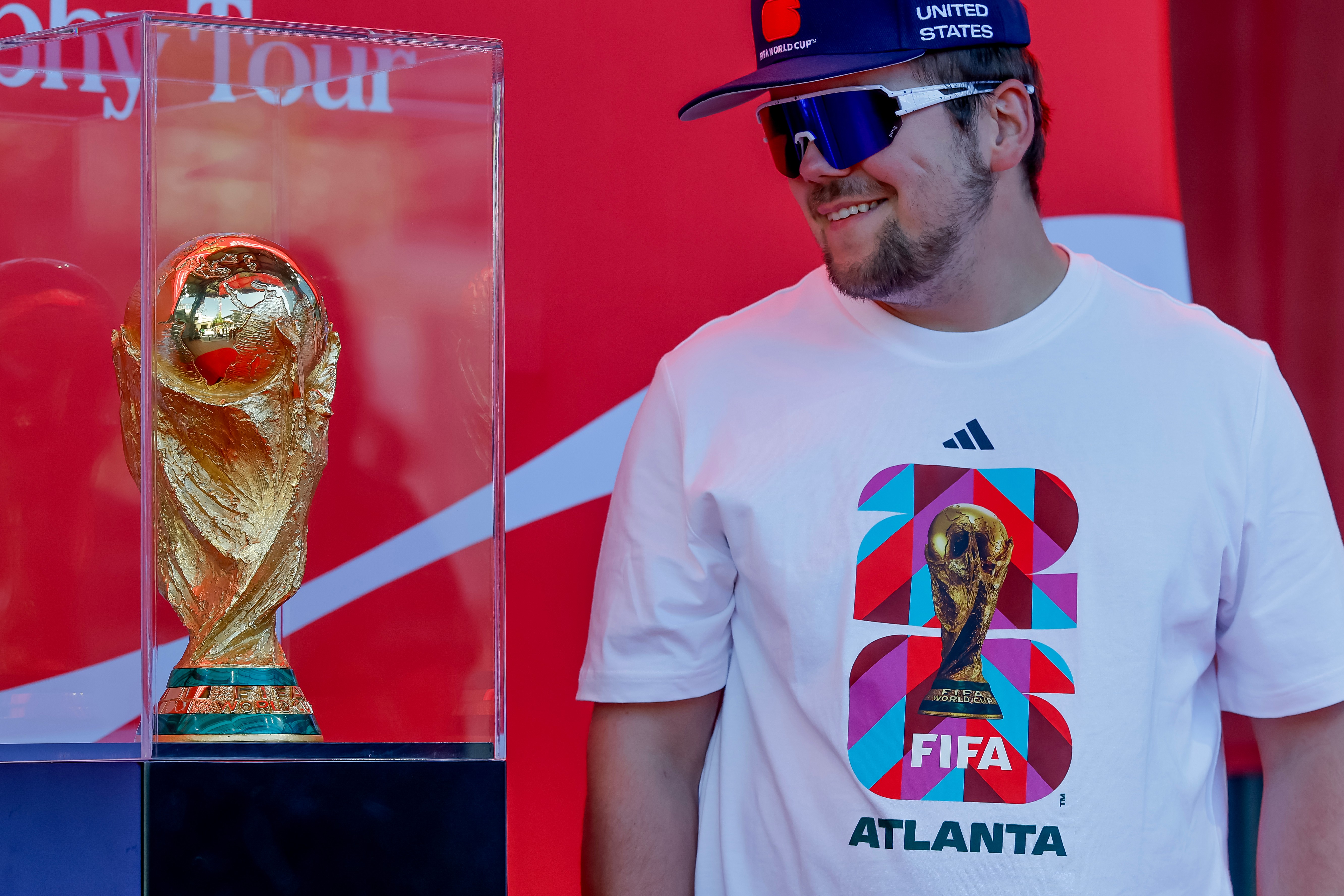 Soccer fan Joseph Pozdnakov has his photo taken during the FIFA World Cup Trophy Tour outside Truist Park before the Atlanta Braves host the Chicago Cubs in a baseball game, Thursday, May 14, 2026, in Atlanta. Eight FIFA World Cup soccer matches will be played in Atlanta.