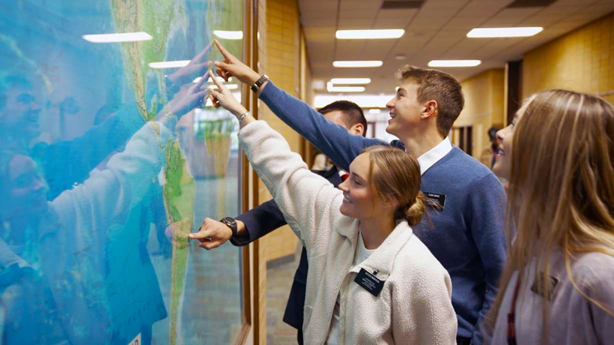 Missionaries point to their assigned missions on a map at the Missionary Training Center in Provo during the filming of the video, “What It’s Like Inside the Missionary Training Center.”