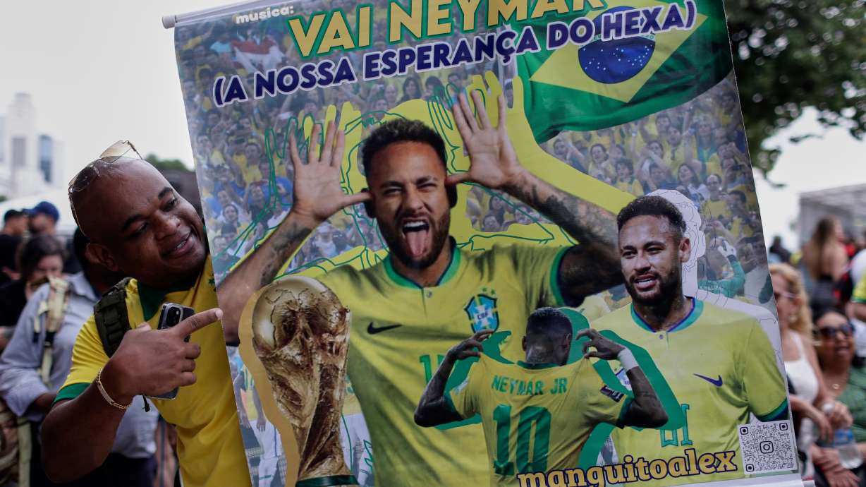 A fan poses with a poster of Brazilian soccer player Neymar, reading in Portuguese "Go Neymar, our hope for a sixth World Cup title" before Brazil's 2026 World Cup squad is announced, in Rio de Janeiro, Monday, May 18, 2026.