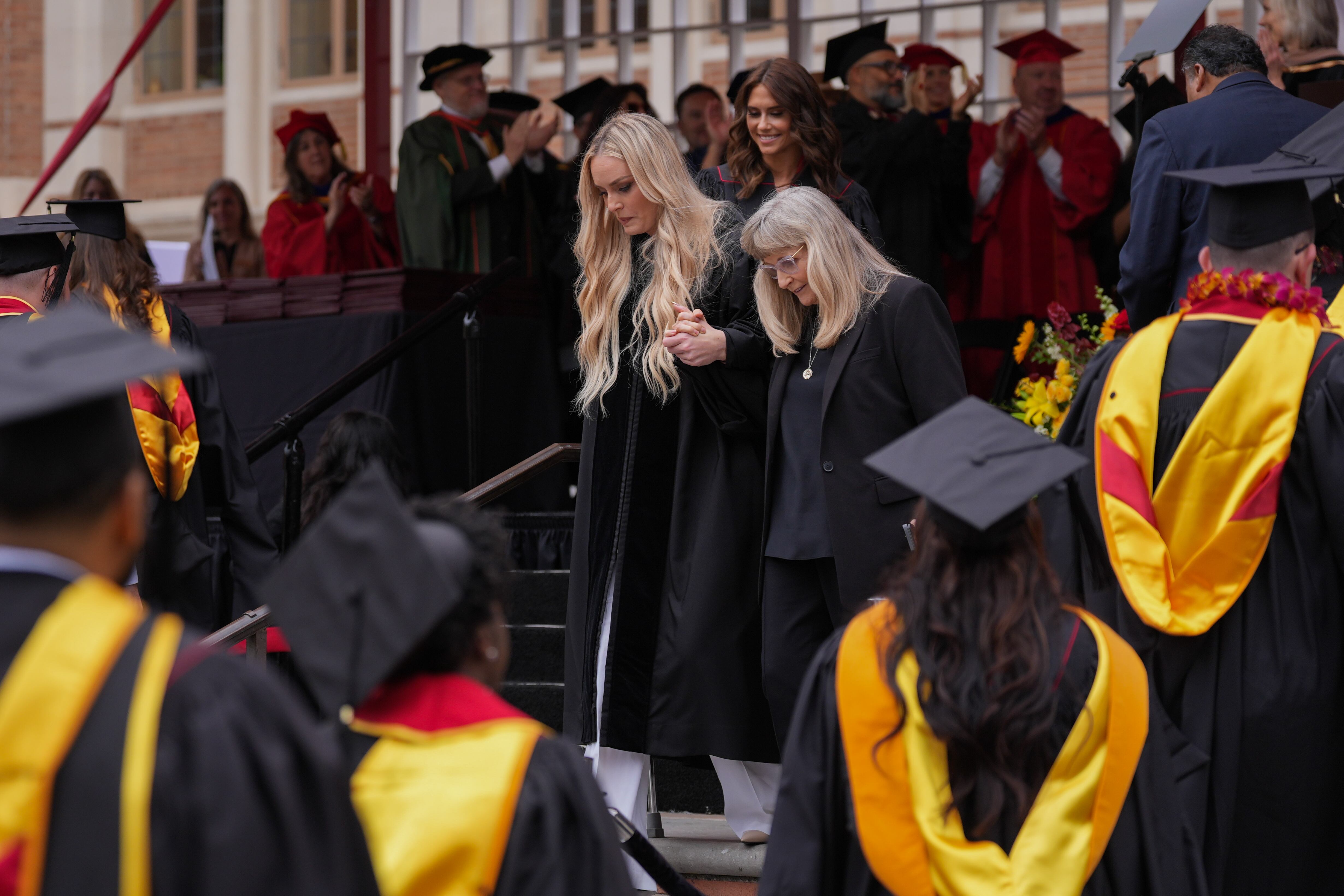 Alpine ski racer Lindsey Vonn, center left, is helped down the steps after her commencement address for the University of Southern California's Annenberg School for Communication and Journalism in Los Angeles, Friday.