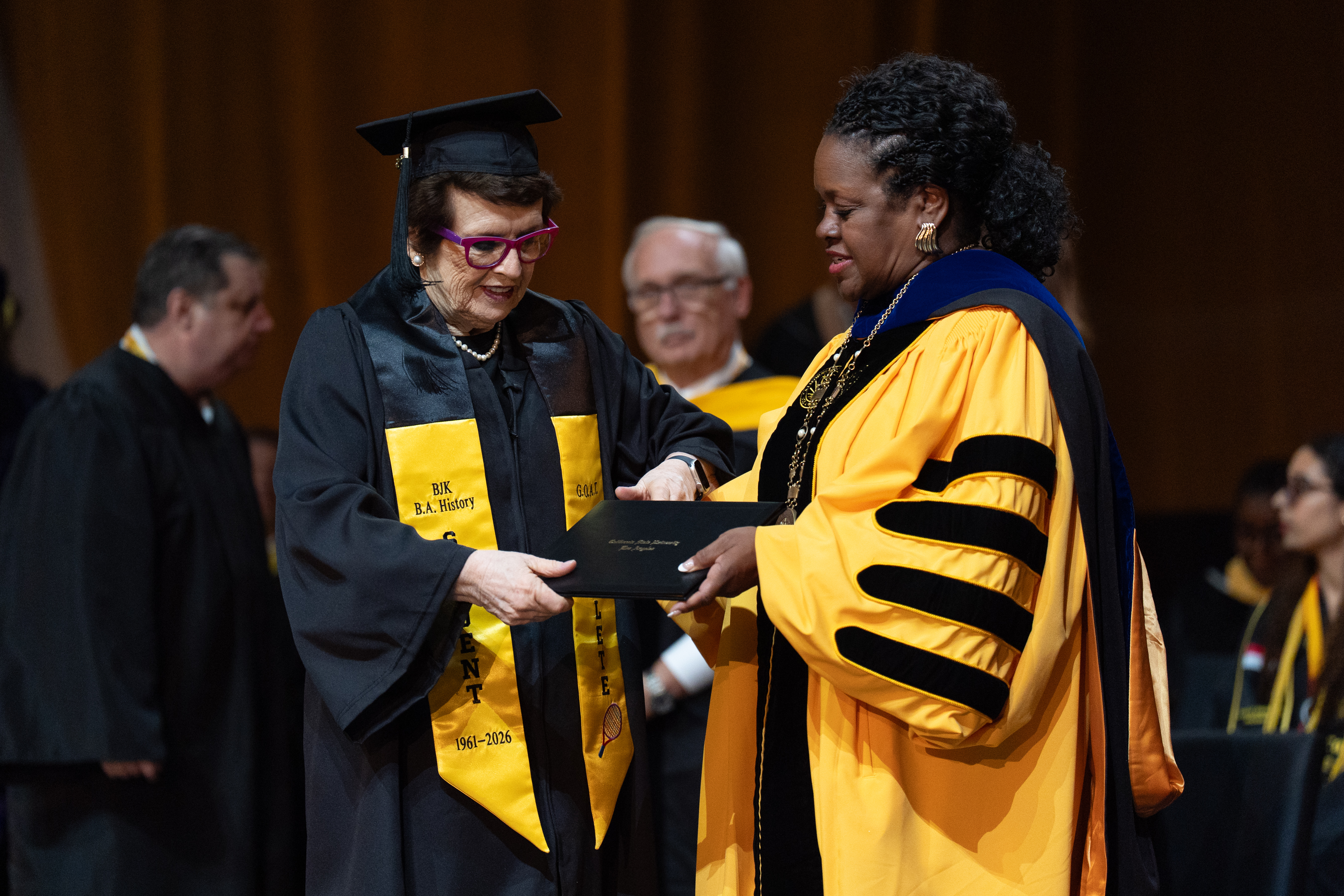 Tennis legend Billie Jean King, left, receives her diploma from California State University, Los Angeles, President Berenecea Johnson Eanes during commencement in Los Angeles, Monday, May 18, 2026.