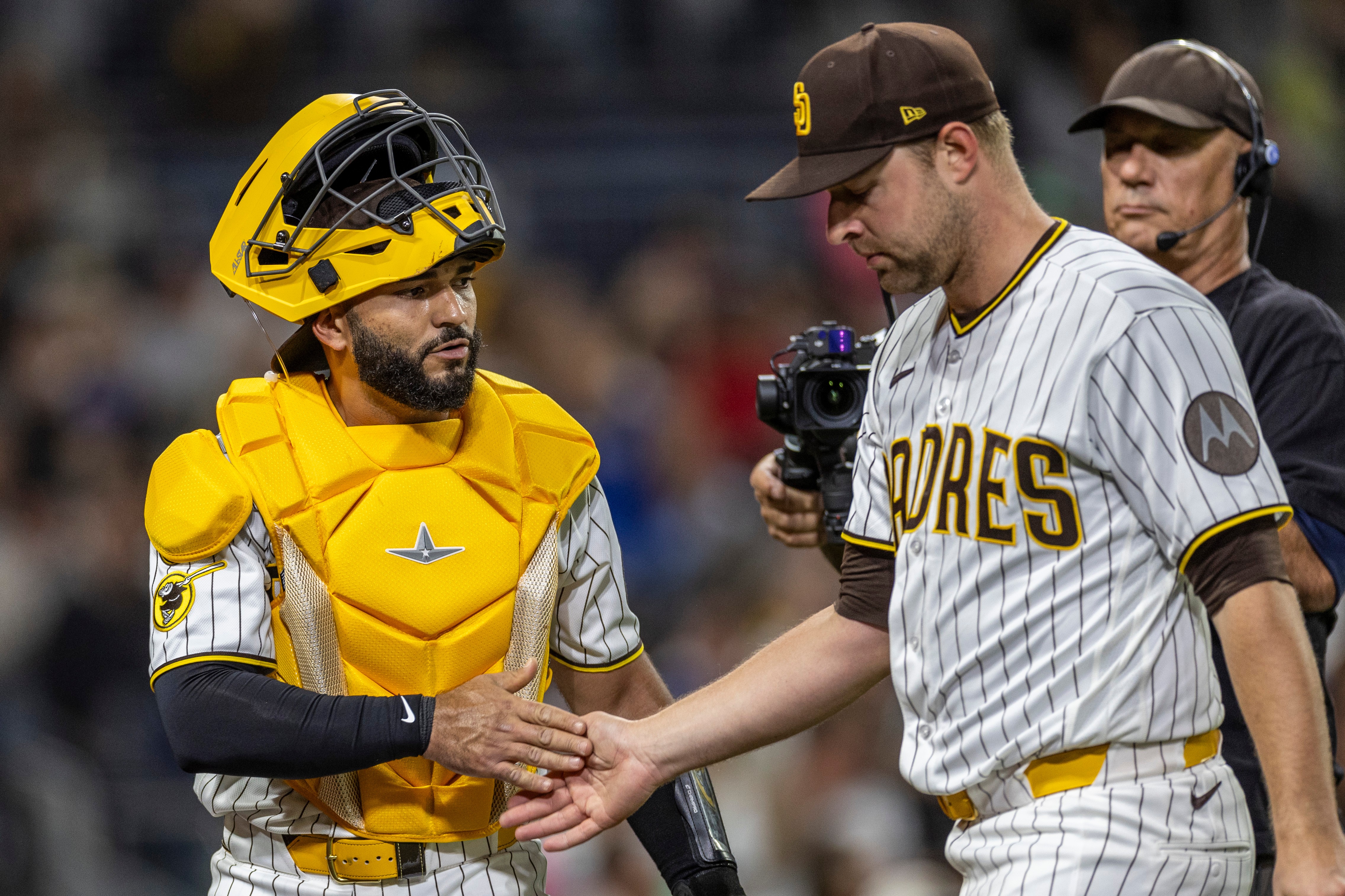 San Diego Padres catcher Rodolfo Durán, left, gives a hand to starting pitcher Michael King, front right, after the in the sixth inning of a baseball game against the Los Angeles Dodgers, Monday, May 18, 2026, in San Diego. 