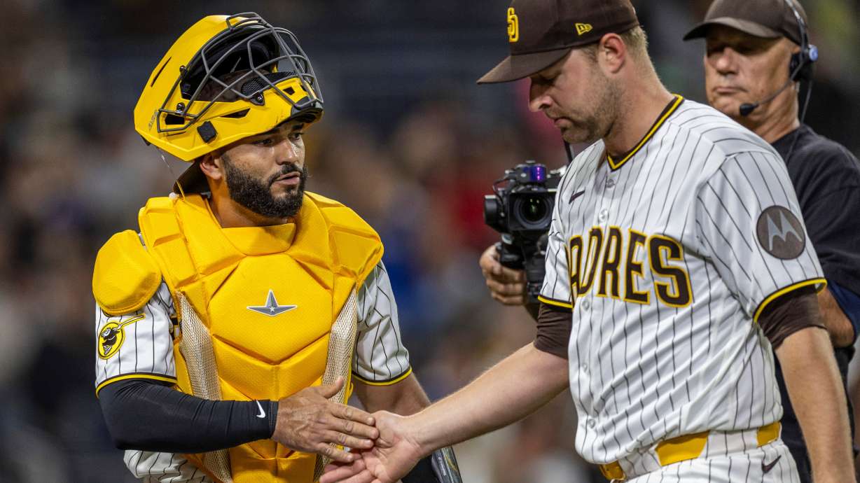 San Diego Padres catcher Rodolfo Durán, left, gives a hand to starting pitcher Michael King, front right, after the in the sixth inning of a baseball game against the Los Angeles Dodgers, Monday, May 18, 2026, in San Diego.