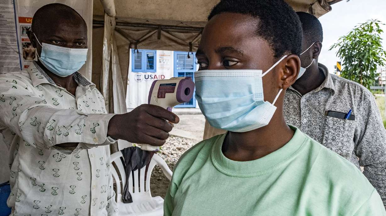 A border health officer at the Busunga crossing between Uganda and the Democratic Republic of Congo checks a traveler's temperature in Bundibugyo, on Monday.