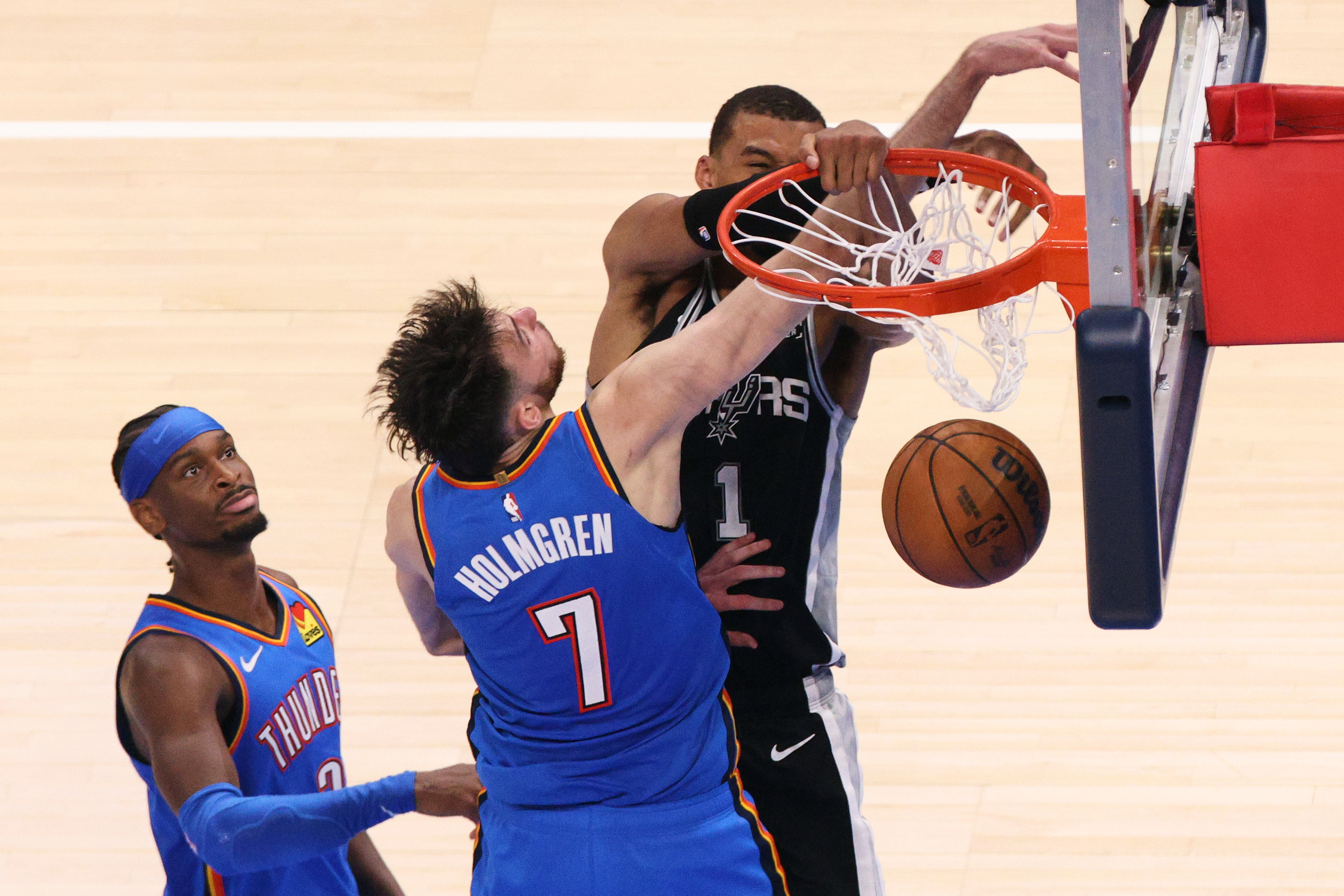 San Antonio Spurs forward Victor Wembanyama (1) dunks while being fouled by Oklahoma City Thunder center Chet Holmgren (7) during the second overtime of Game 1 in a third-round NBA basketball playoffs series Monday, May 18, 2026, in Oklahoma City. 
