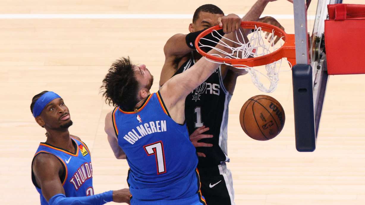 San Antonio Spurs forward Victor Wembanyama (1) dunks while being fouled by Oklahoma City Thunder center Chet Holmgren (7) during the second overtime of Game 1 in a third-round NBA basketball playoffs series Monday, May 18, 2026, in Oklahoma City.