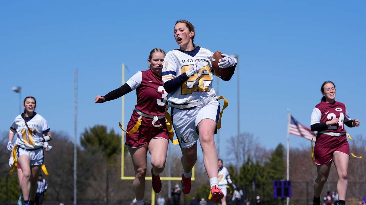 FILE - An Augustana University player, front, runs from a Concordia University, St. Paul player during a women's college flag football game, April 7, 2025, in St. Paul. Minn.