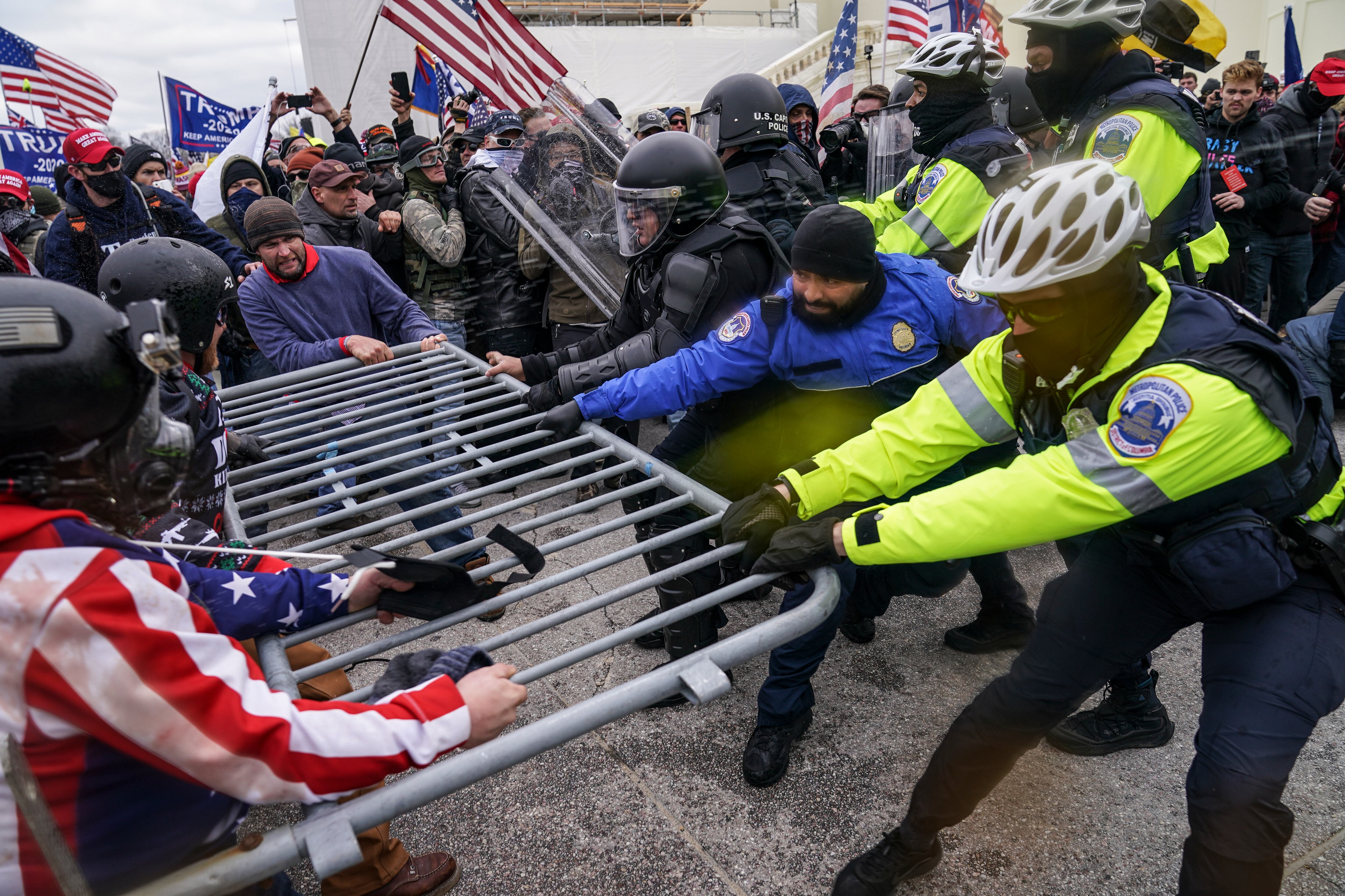 Supporters of President Donald Trump try to break through a police barrier, Jan. 6, 2021, during a riot at the Capitol in Washington.
