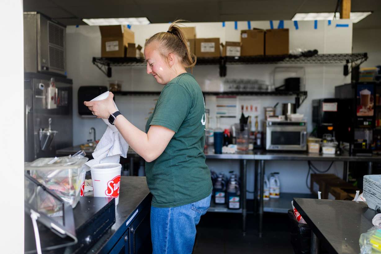 Swig employee Morgan Butcher works the window at a Swig in Draper on March 12.