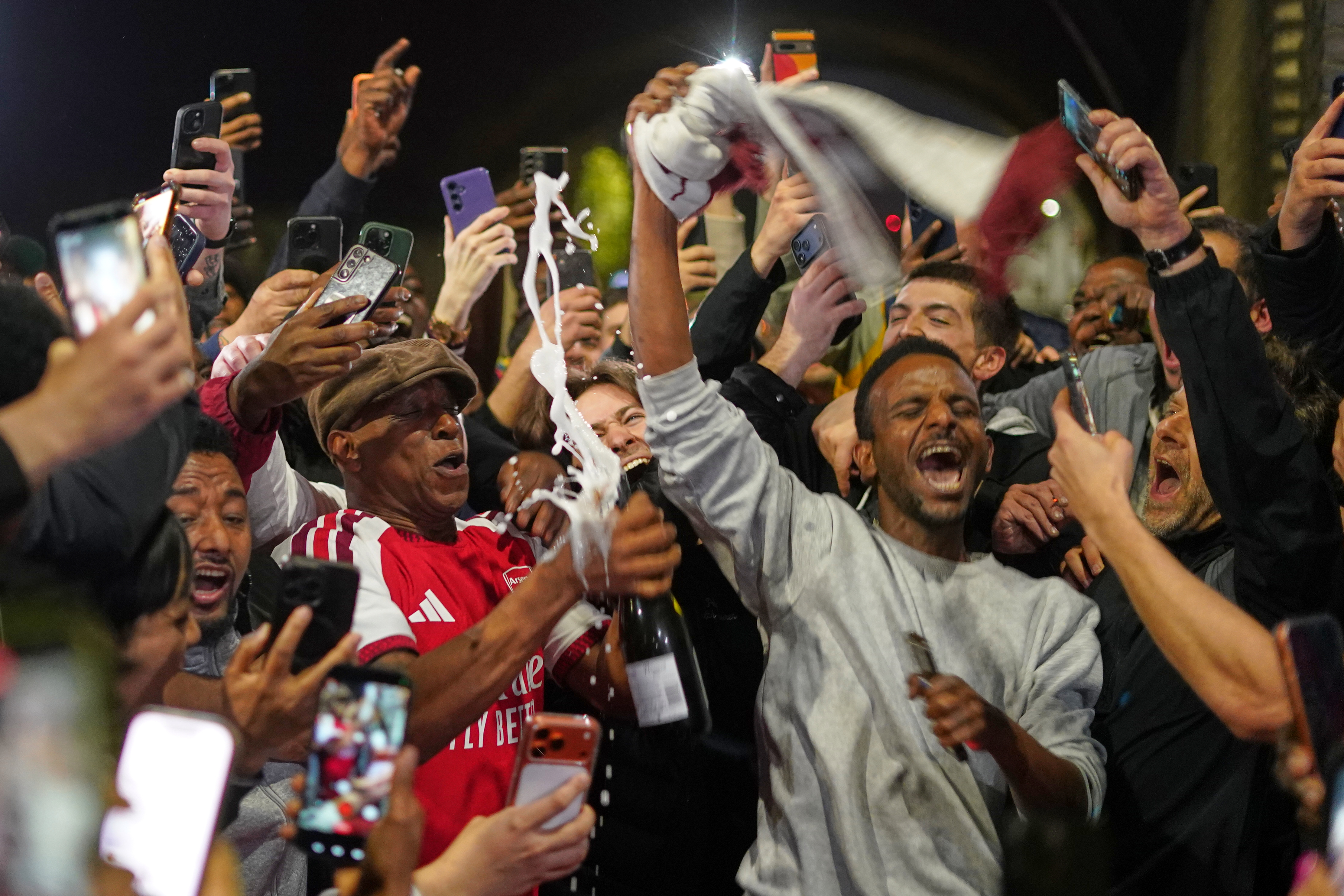 Former Arsenal player Ian Wright celebrates with Arsenal supporters at the Arsenal stadium after Arsenal's soccer team won the Premier League title in London, Tuesday, May 19, 2026.