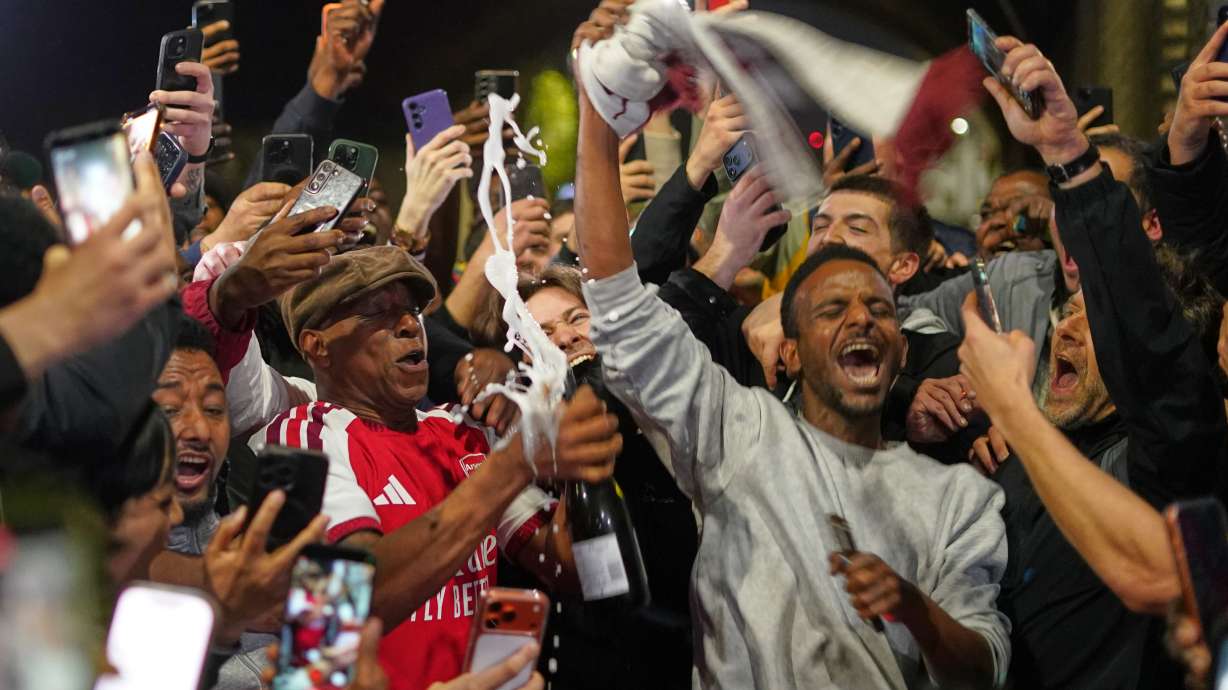 Former Arsenal player Ian Wright celebrates with Arsenal supporters at the Arsenal stadium after Arsenal's soccer team won the Premier League title in London, Tuesday, May 19, 2026.