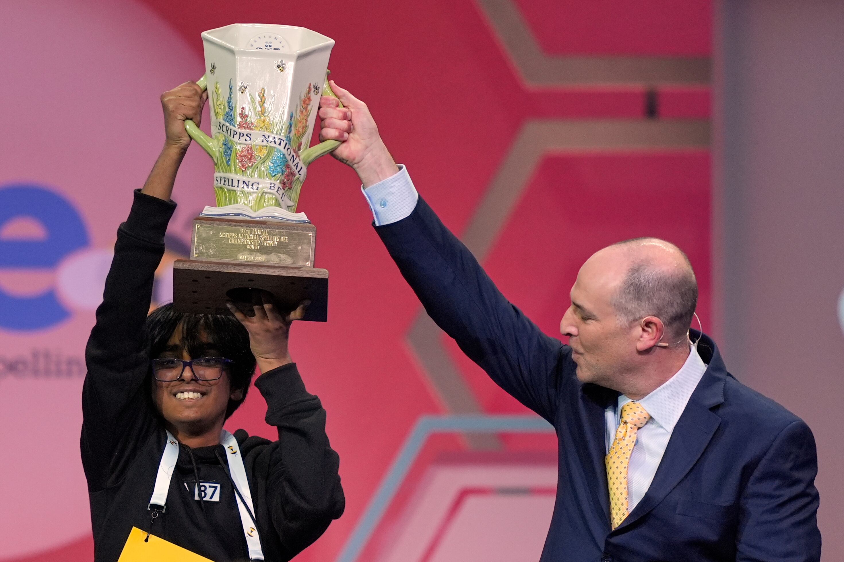 E.W. Scripps Company president and CEO Adam Symson presents the trophy to Faizan Zaki, 13, of Dallas, the winner of the 2025 Scripps National Spelling Bee, May 29, 2025, in Oxon Hill, Md.