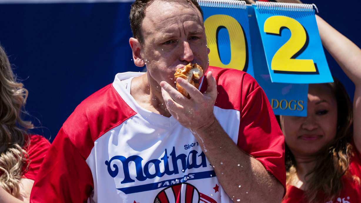 FILE - Joey Chestnut eats hot dogs during the 2025 Nathan's Famous Fourth of July hot dog eating contest in the Coney Island section of the Brooklyn borough of New York, July 4, 2025.