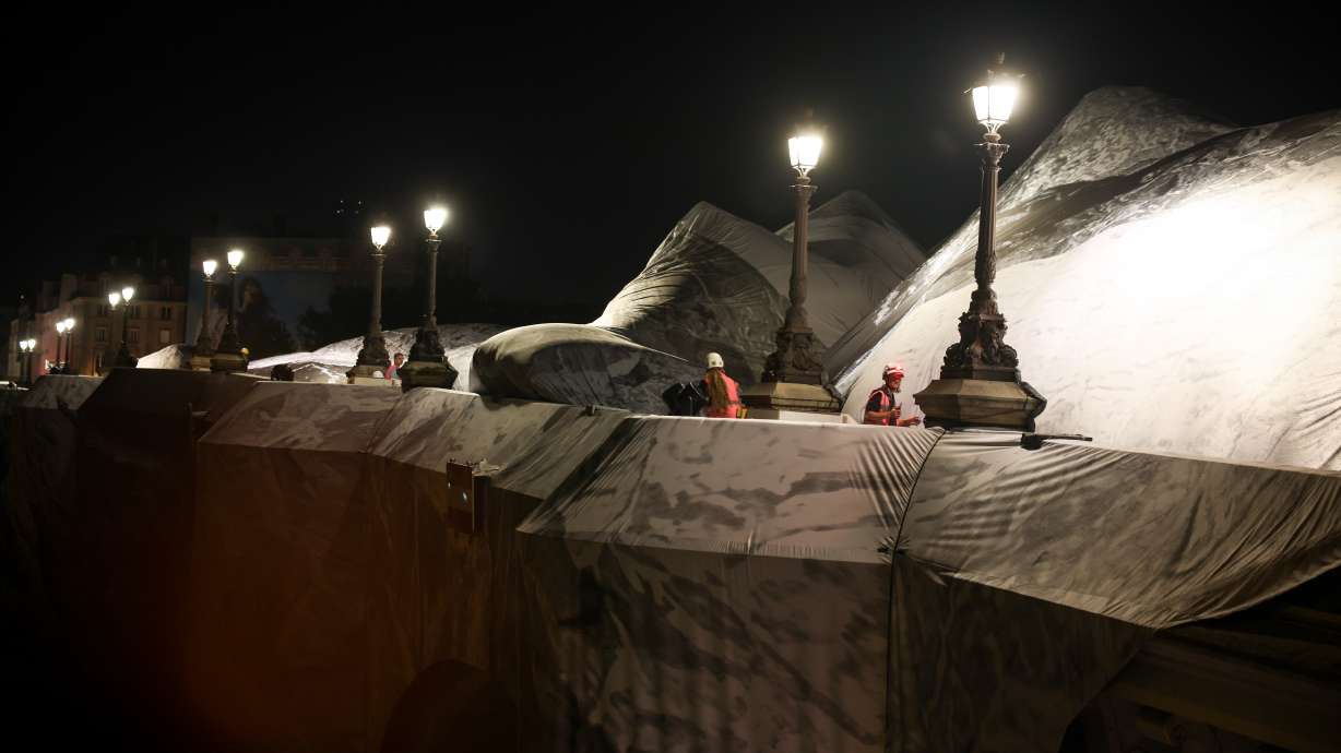A worker monitors the inflation of "The Pont Neuf Cave" by French street artist JR on the Pont Neuf bridge in Paris on Wednesday, before its free public opening from June 6 to June 28.
