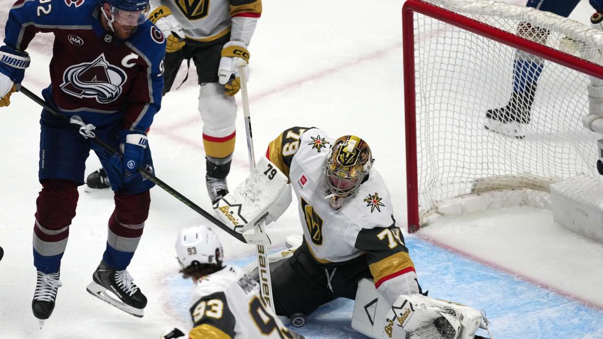 Vegas Golden Knights goaltender Carter Hart, right, stops a shot off the stick of Colorado Avalanche left wing Gabriel Landeskog during the third period in Game 1 of the Western Conference finals NHL hockey Stanley Cup playoff series Wednesday, May 20, 2026, in Denver.