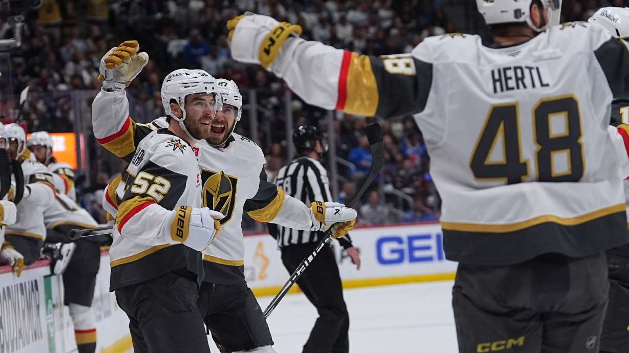 Vegas Golden Knights defenseman Dylan Coghlan, front left, is congratulated after scoring a goal by defenseman Shea Theodore, back left, and center Tomas Hertl during the second period in Game 1 of the Western Conference finals NHL hockey Stanley Cup playoff series against the Colorado Avalanche Wednesday, May 20, 2026, in Denver.