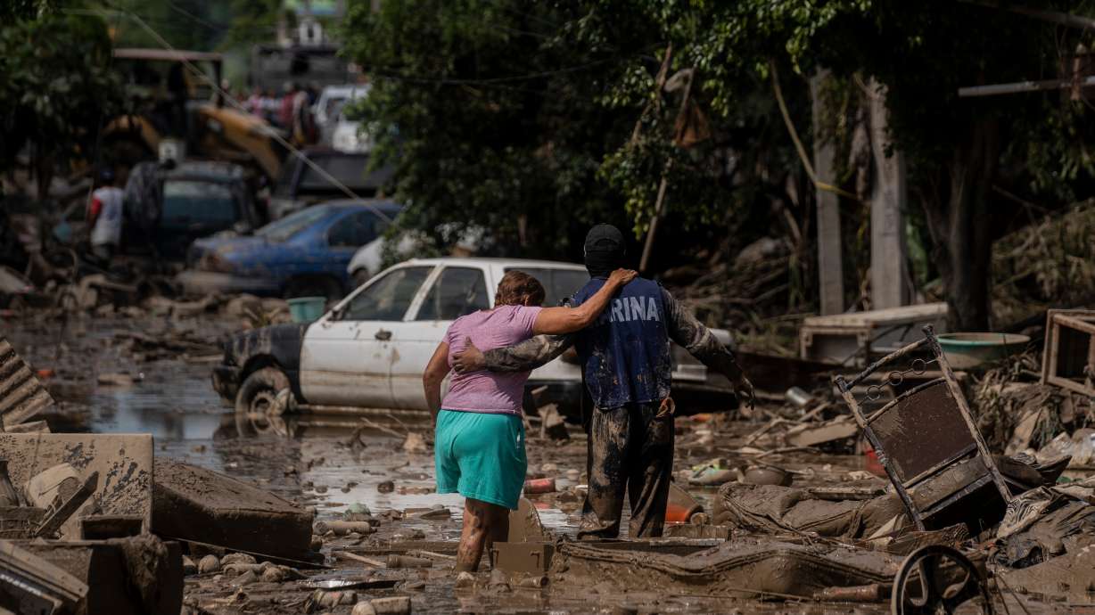 A Navy officer helps a woman cross a flooded street in Poza Rica, Veracruz state, Mexico, Oct. 12. El Niño is forecast to dampen Atlantic activity and strengthen Pacific activity this hurricane season, according to forecasts released on Thursday.