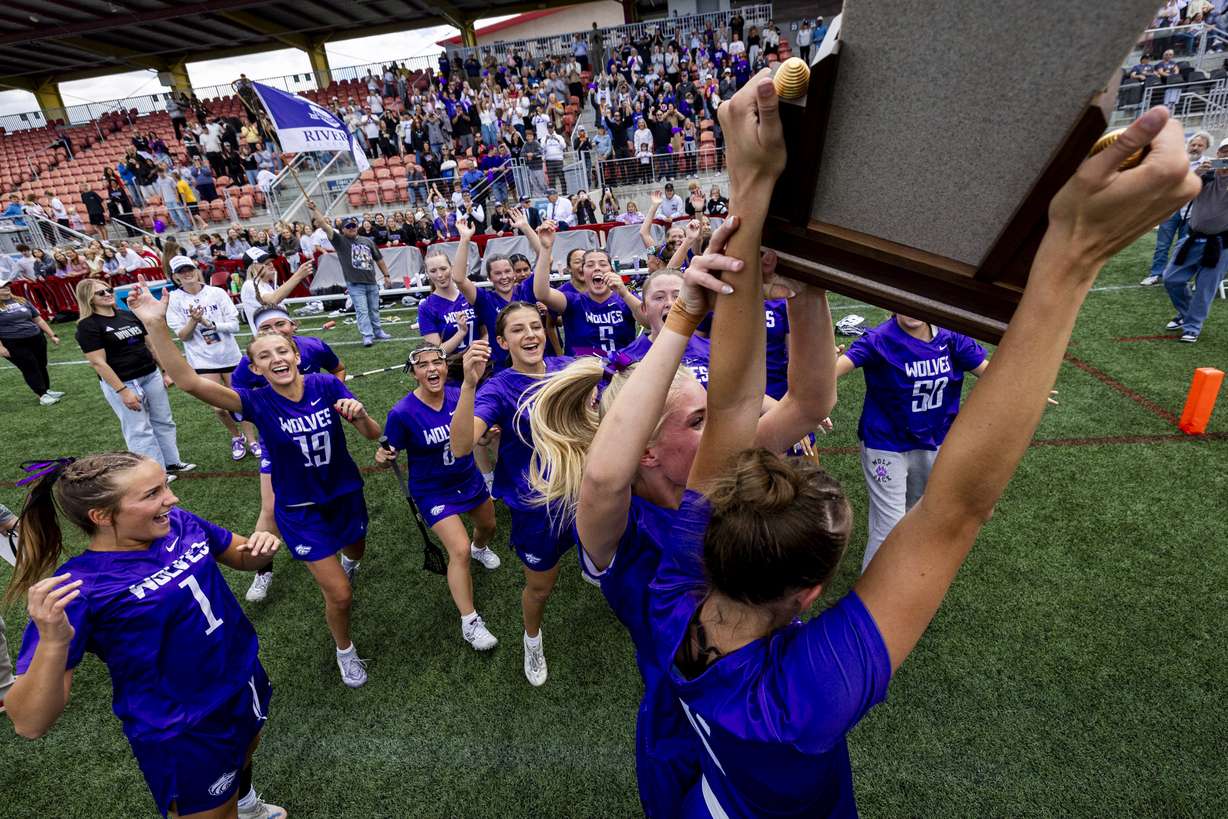 Riverton players celebrate around the championship trophy after defeating Skyridge in overtime during the 6A girls lacrosse state championship game, held at Zions Bank Stadium in Herriman on Thursday, May 21, 2026.