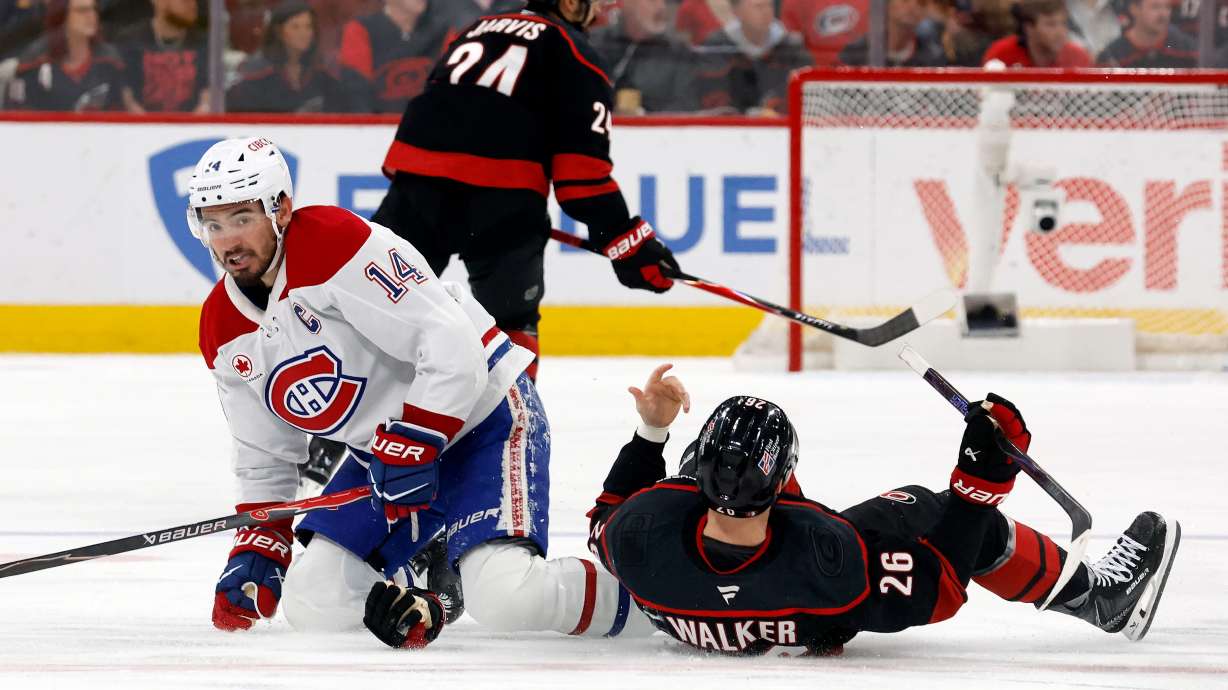 Montréal Canadiens' Nick Suzuki (14) collides with Carolina Hurricanes' Seth Jarvis (24) resulting in both getting penalties during the first period in Game 1 of the Eastern Conference finals NHL hockey Stanley Cup playoffs series in Raleigh, N.C., Thursday, May 21, 2026.