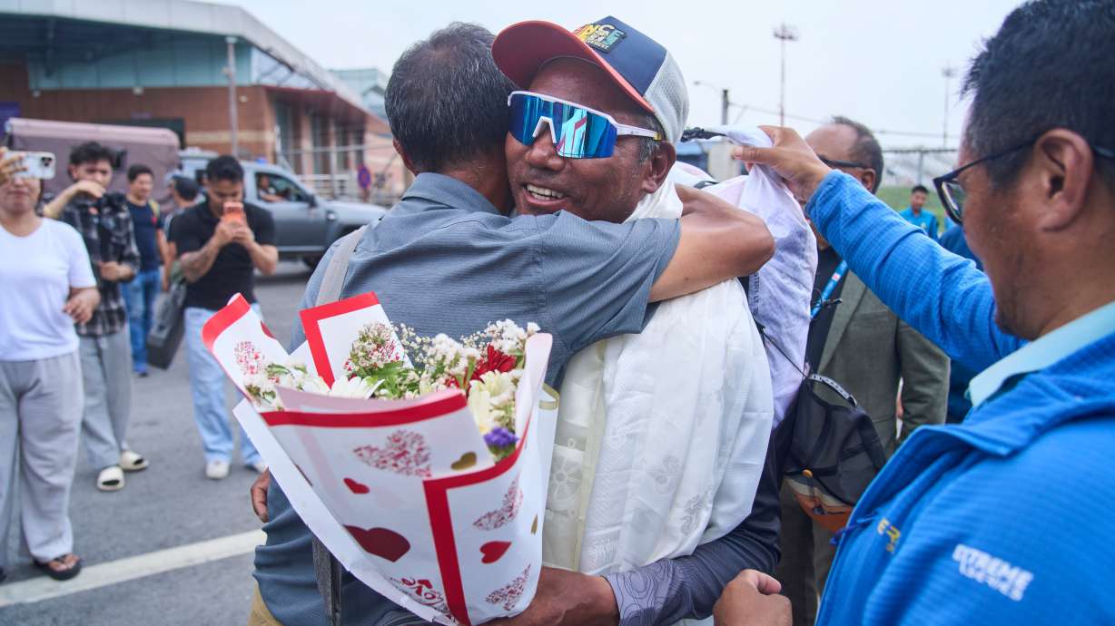 Renowned Sherpa mountain guide Kami Rita, center right, returning from Mount Everest after his record 32nd successful ascent is presented with shawls and flowers as he arrives at an airport in Kathmandu, Nepal, Friday, May 22, 2026.