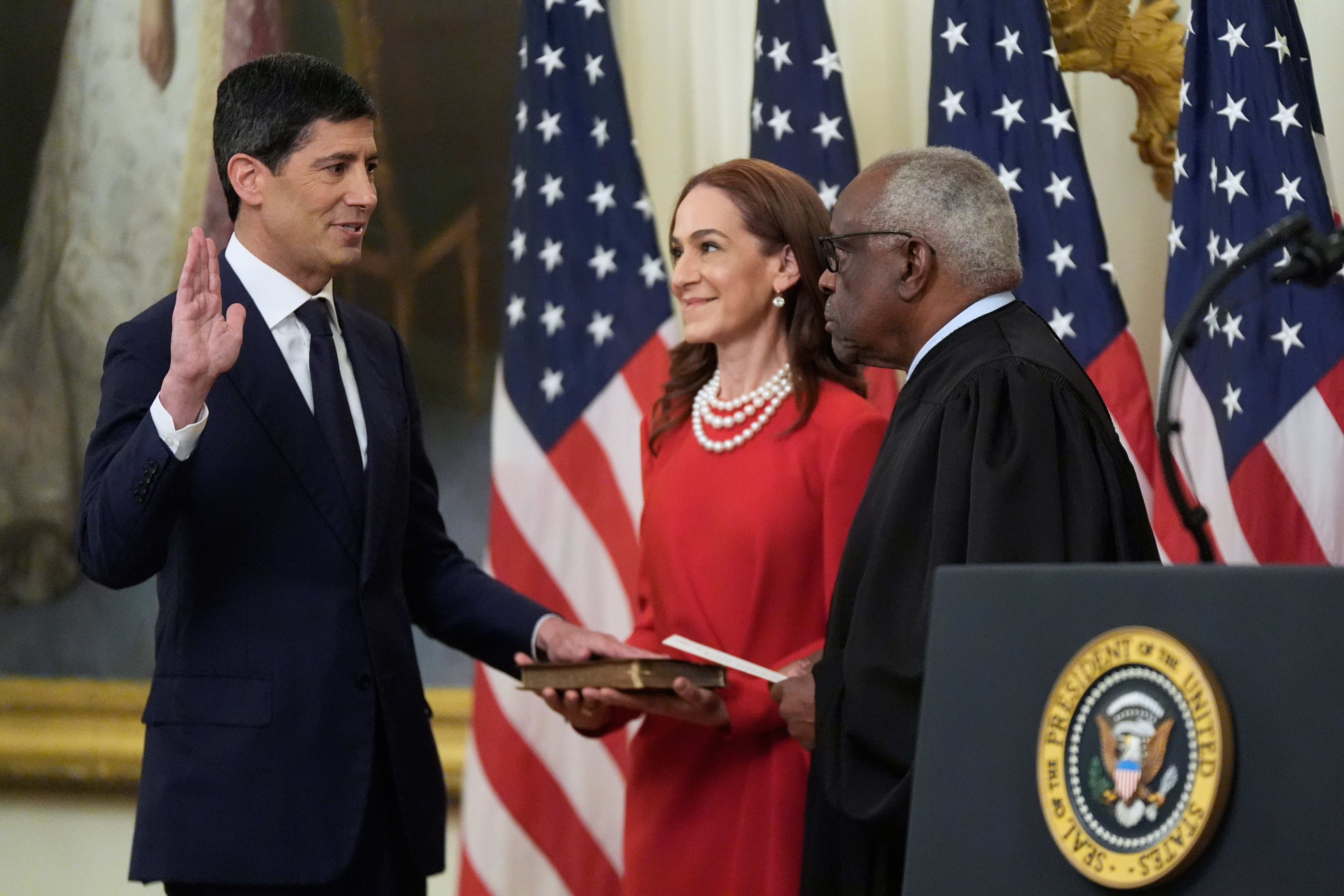 Supreme Court Justice Clarence Thomas administers the oath of office to Kevin Warsh as chair of the Federal Reserve in the East Room of the White House, Friday in Washington, as Warsh's wife, Jane Lauder, looks on. Warsh called it the "honor of a lifetime" to return to public service.