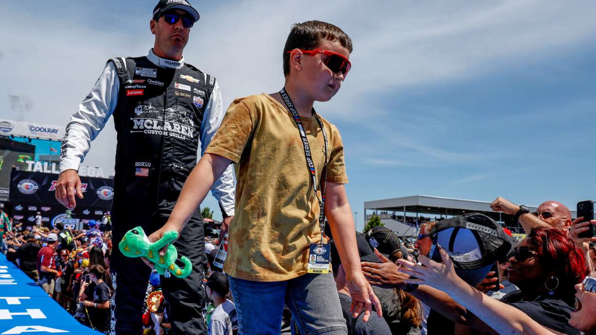 FILE - Kyle Busch, left, and his son greet fans before a NASCAR Cup Series auto race at Talladega Superspeedway, April 23, 2023, in Talladega, Ala.