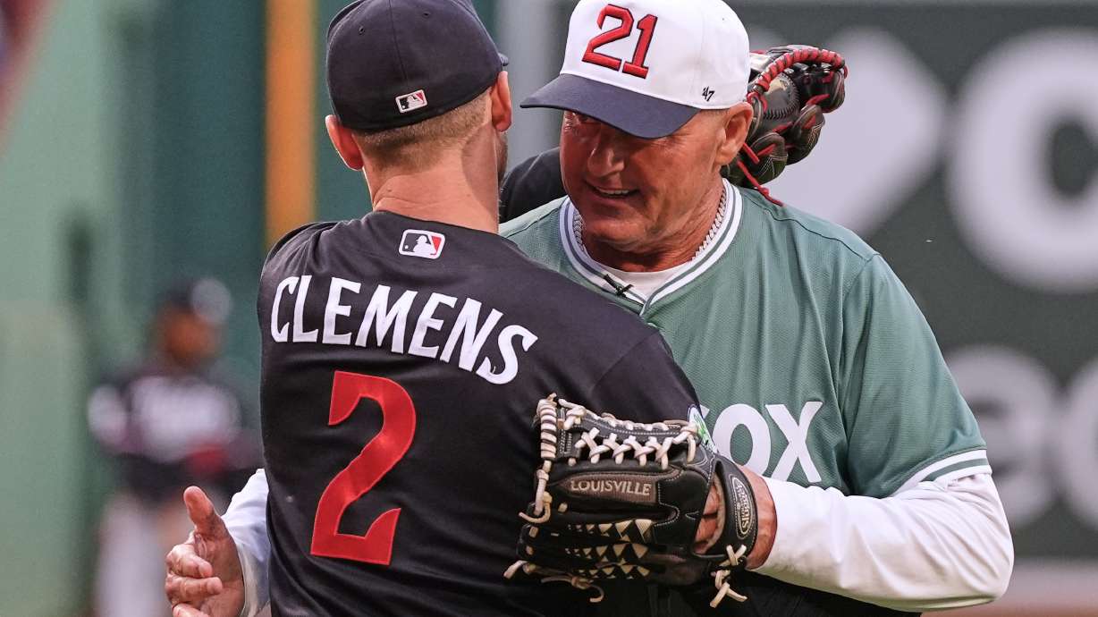 Former Boston Red Sox pitcher Roger Clemens, right, embraces his son, left, Minnesota Twins' Kody Clemens (2), after throwing out a ceremonial first pitch prior to a baseball game between the teams Friday, May 22, 2026, in Boston.