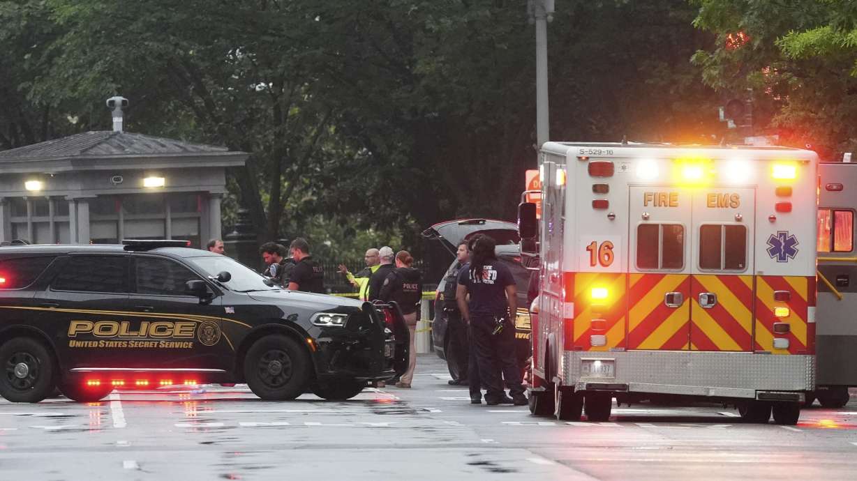 Police and members of the Secret Service stand near an EMS truck after blocking streets around the White House, Saturday, in Washington. An official said the Secret Service shot a person near the White House, and a bystander was also shot.