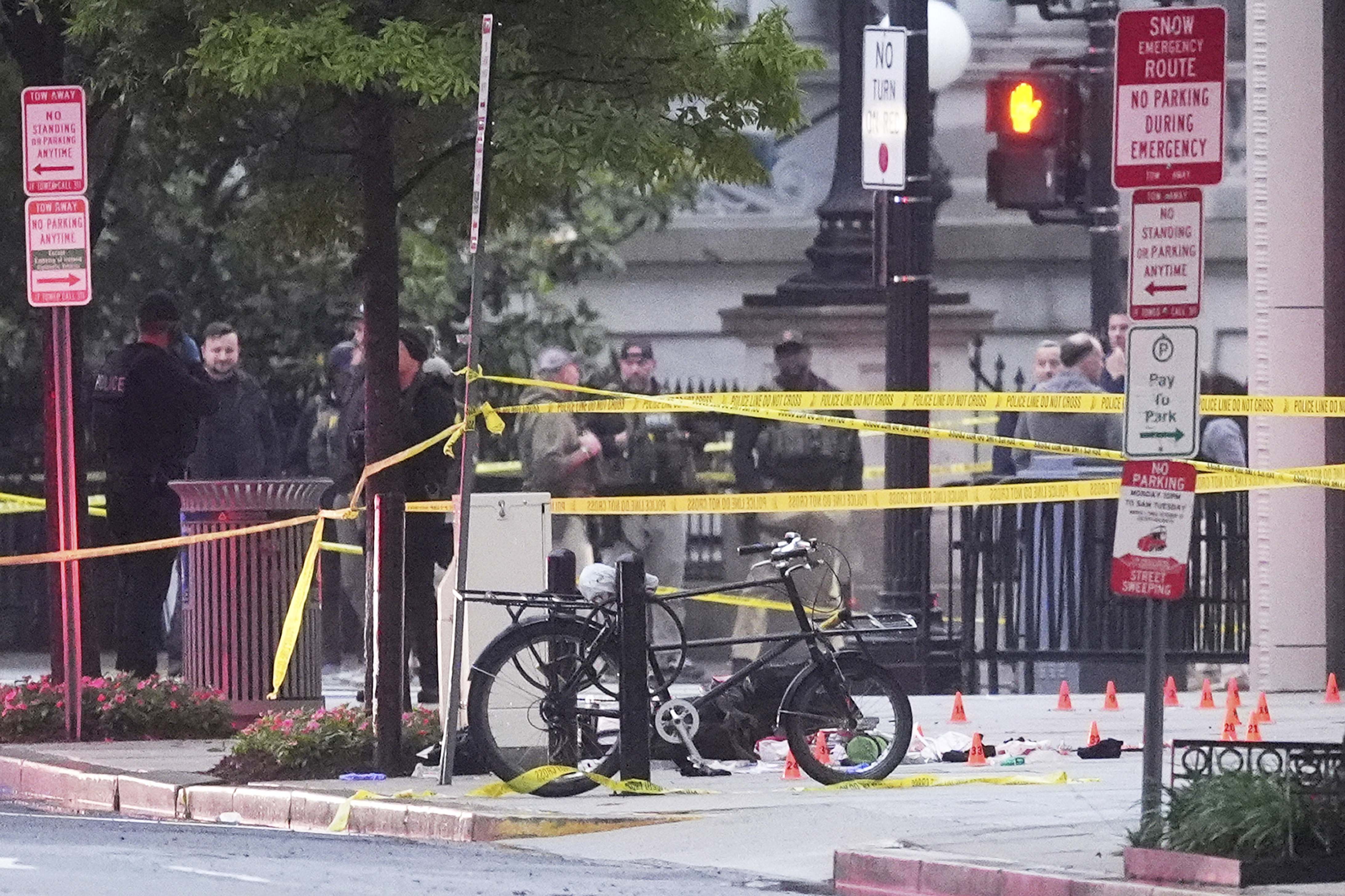 Evidence markers are seen on a crime scene after police responded to reports of shots fired near the White House, Saturday, in Washington. The Secret Service said a suspect who opened fire near a White House security checkpoint was shot and killed.