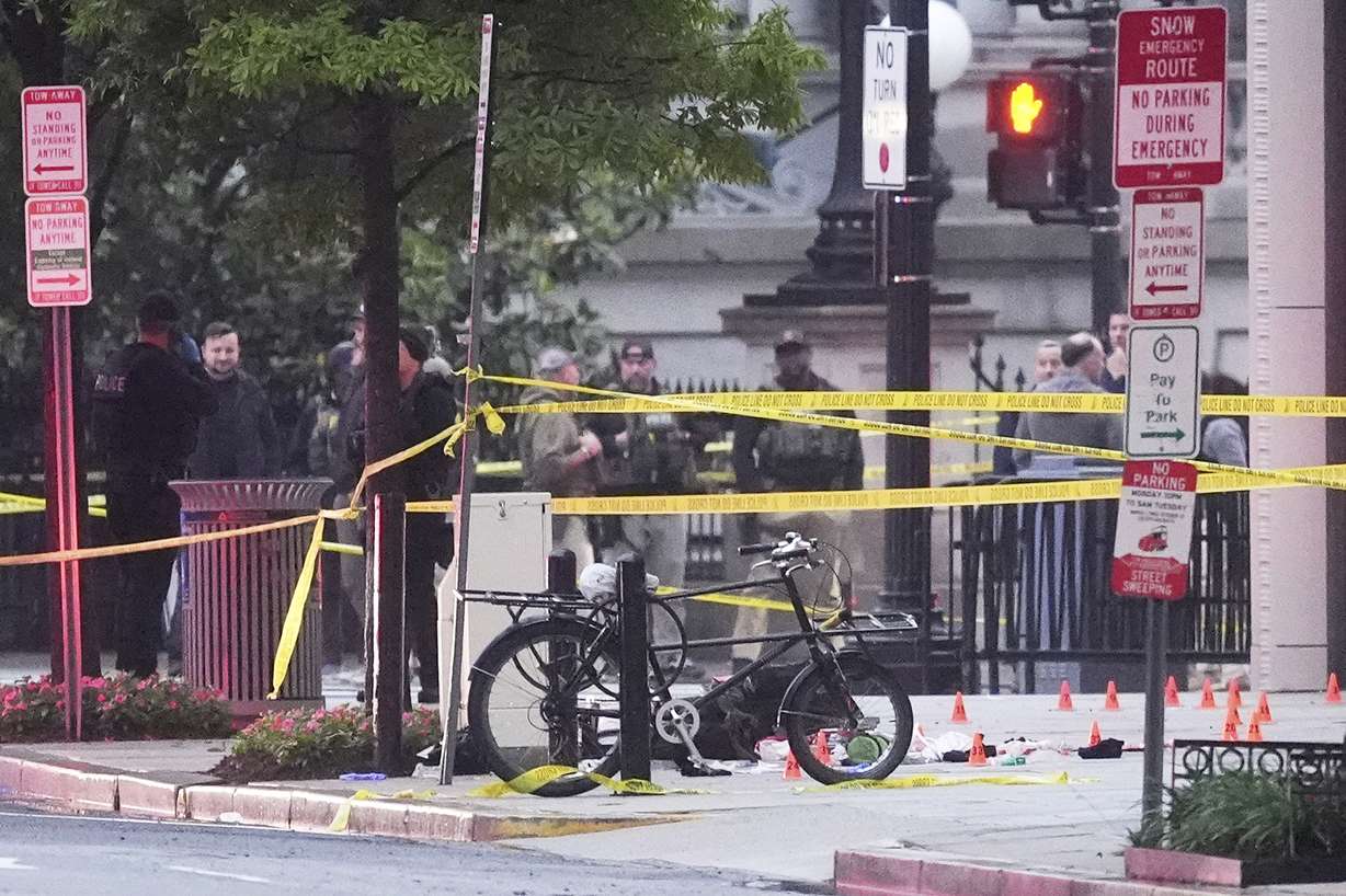 Evidence markers are seen on a crime scene after police responded to reports of shots fired near the White House, Saturday, in Washington. The Secret Service said a suspect who opened fire near a White House security checkpoint was shot and killed.
