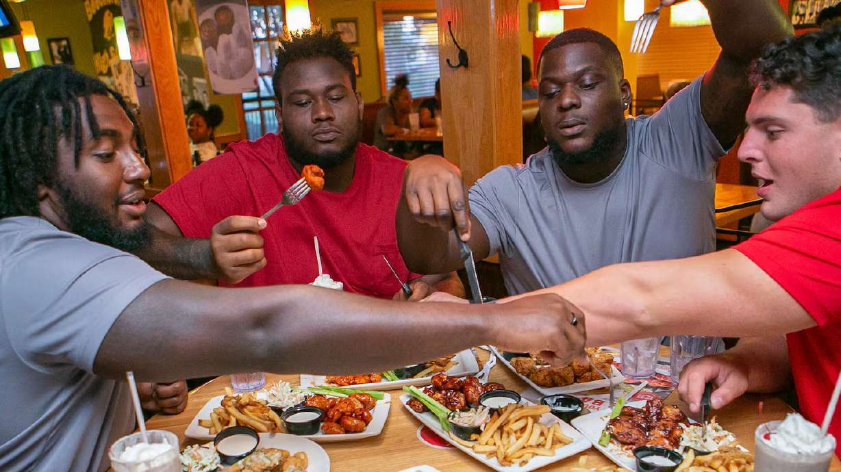 Donovan Jackson, Dawand Jones, Matthew Jones and Luke Wypler enjoy plates of Applebee's boneless wings on Aug. 27, 2022, in Columbus, Ohio. Applebee's is one of many restaurants offering food deals for Memorial Day weekend.