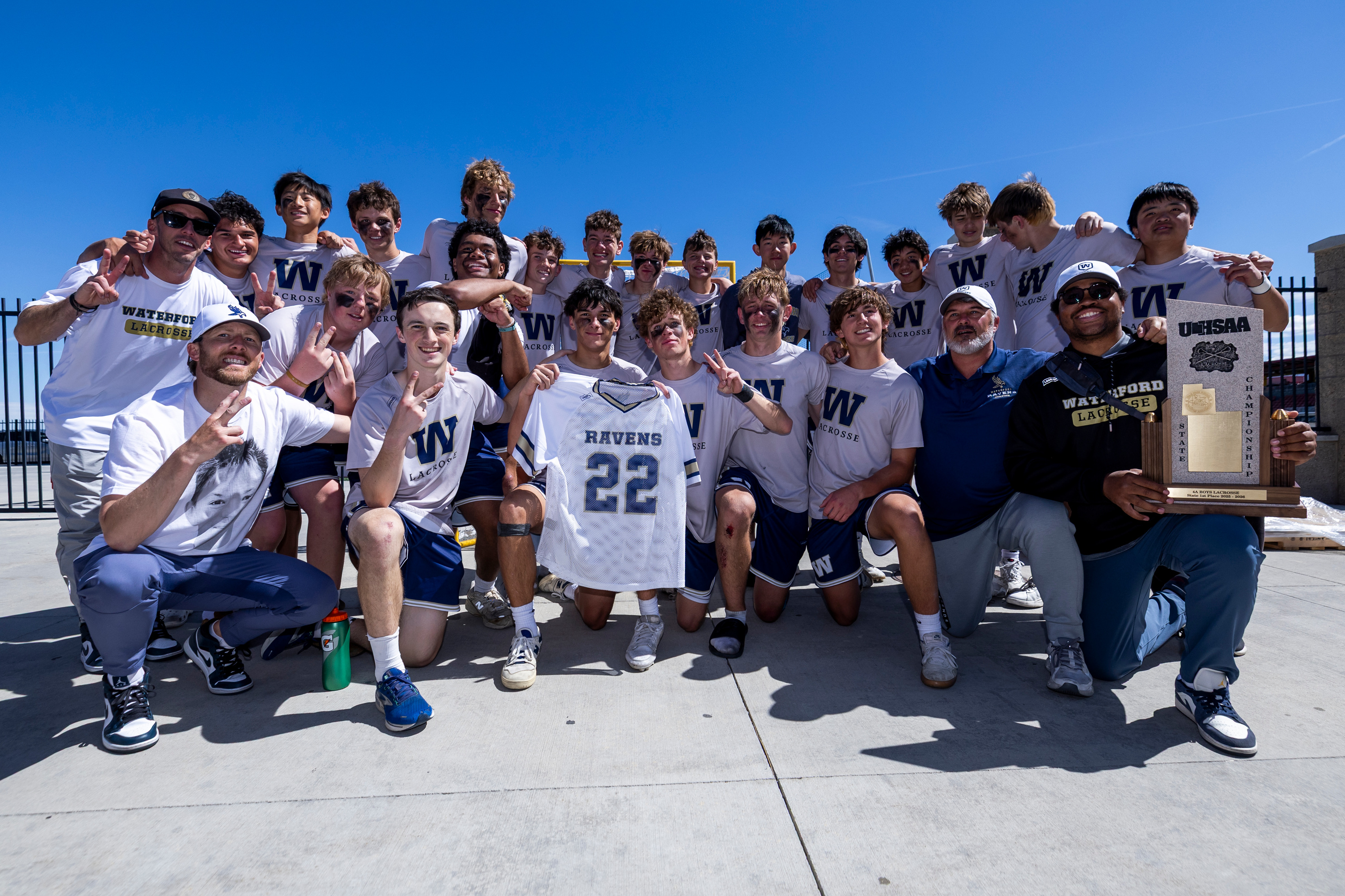 Waterford poses for a photo with the jersey of teammate Steven Jardine (22), who passed away in a car accident last summer, after defeating Juan Diego 7-6 to win the 4A boys lacrosse championship at Zions Bank Stadium in Herriman on Saturday, May 23, 2026.